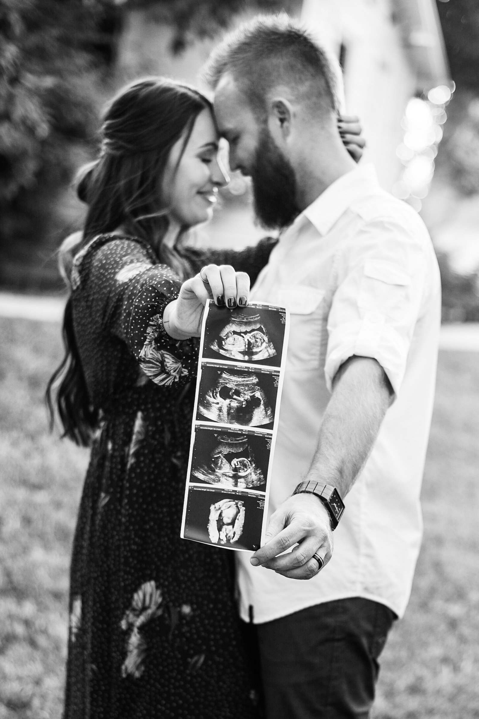 Pregnant couple at Agritopia Farms Chandler holding ultrasound photo black and white touching foreheads  maternity