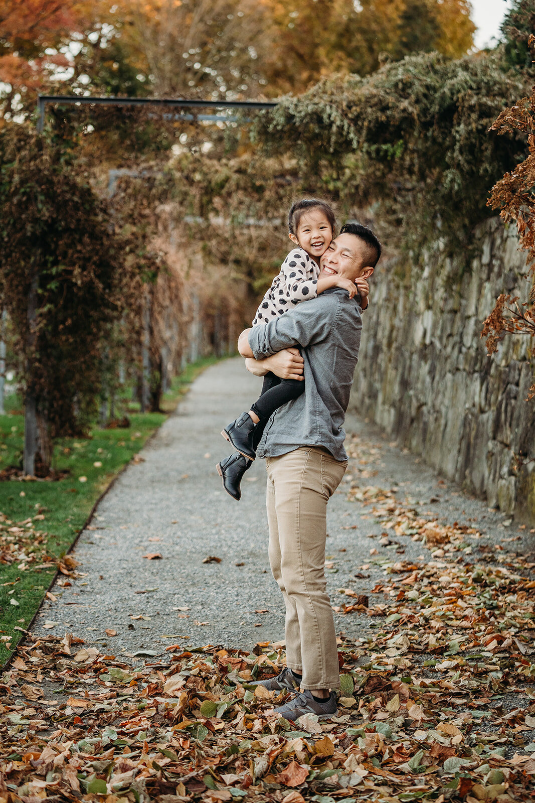 dad picks up daughter and hugs her tight during family photos in boston