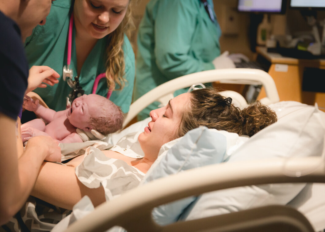 A mother grabs her baby for the first time during her Utah birth story.