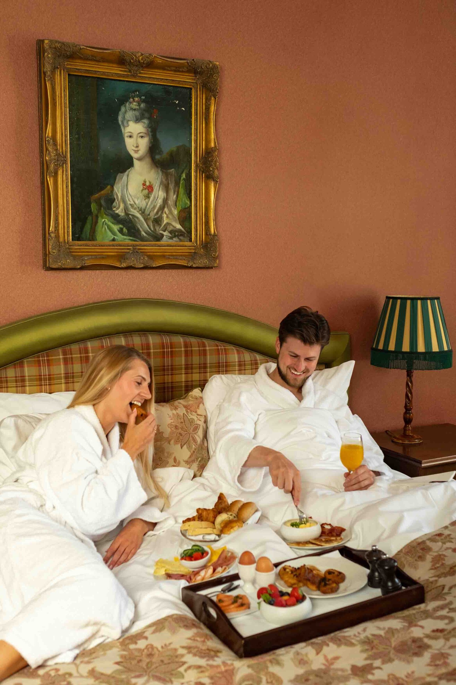 koppel aan het genieten in hun sfeervolle hotelkamer romantisch ontbijt op bed