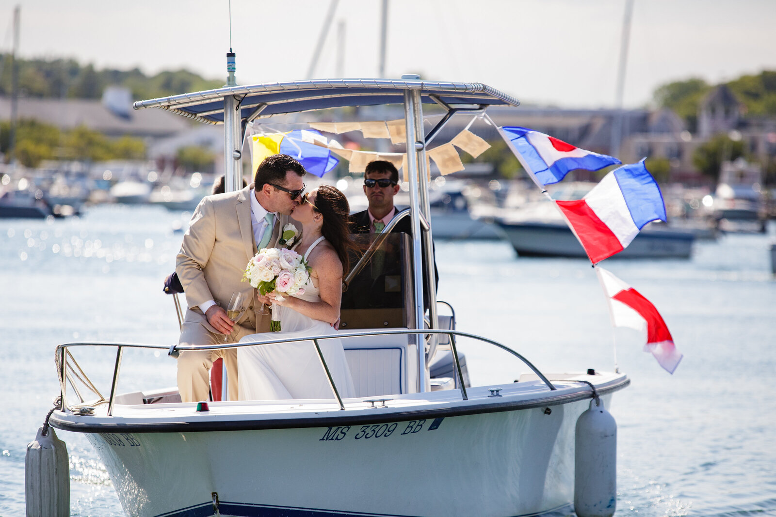 couple kisses on bow of boat in scituate harbor