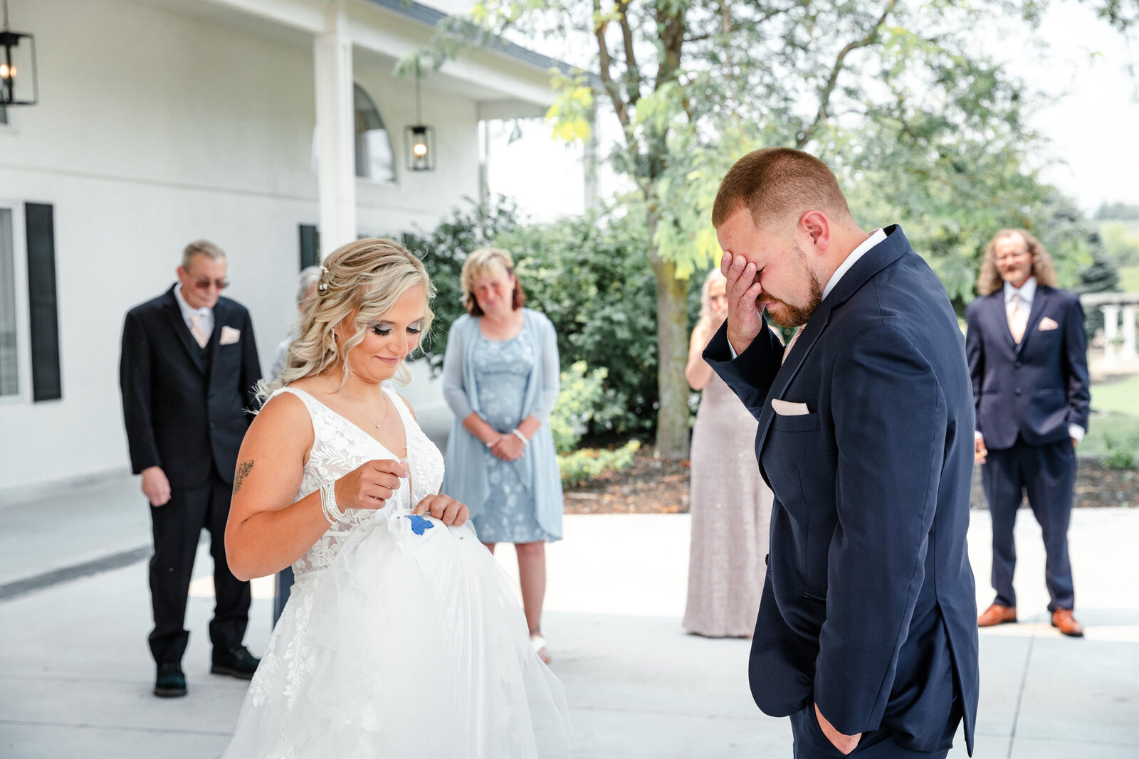 Groom crying as he sees something blue on brides wedding dress