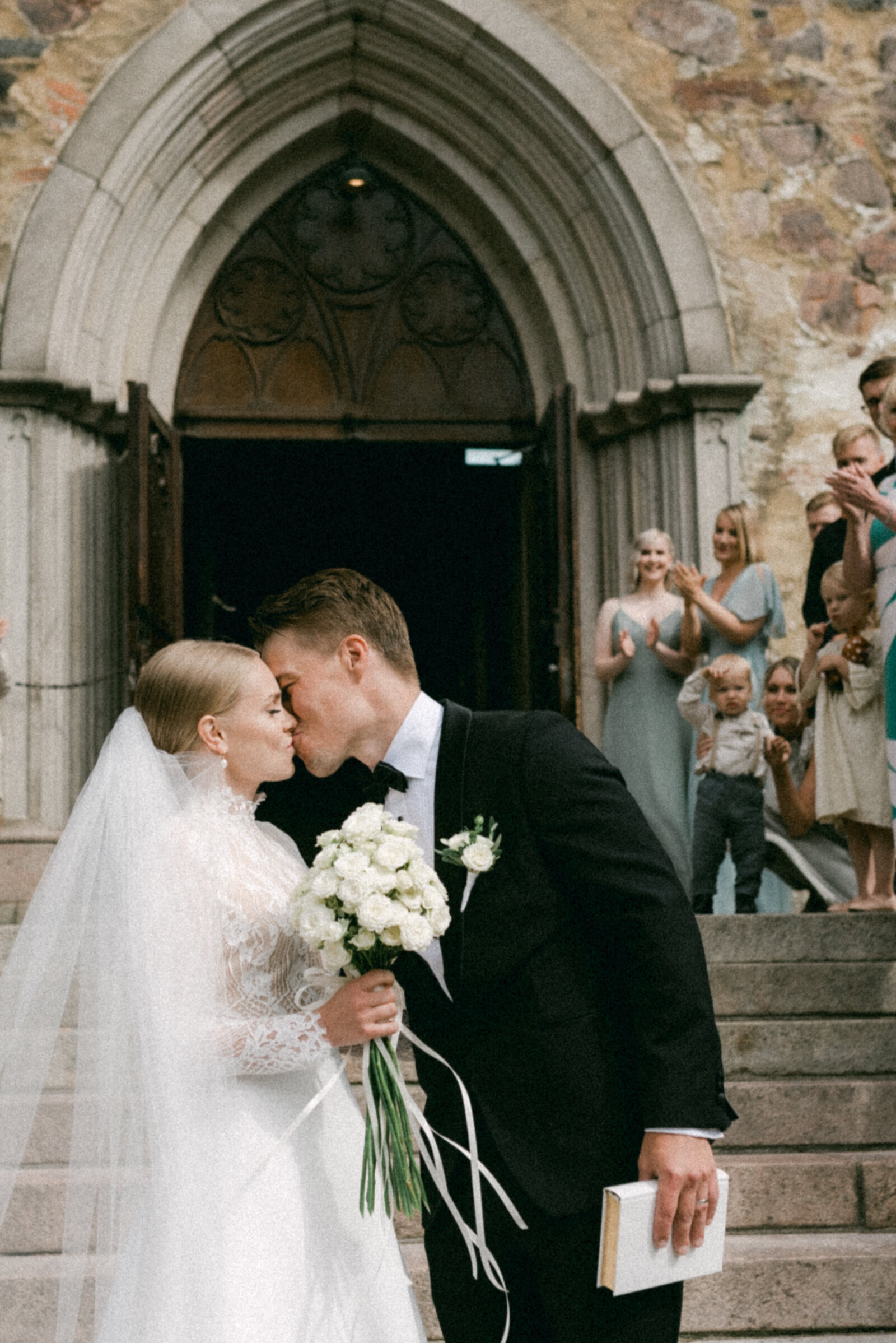 Wedding couple kissing on the stairs of Turku cathedral after their ceremony.  Photography by wedding photographer Hannika Gabrielsson.