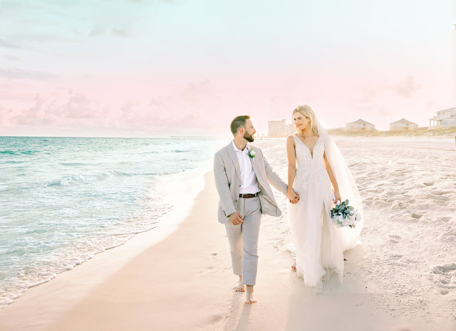 Elegant Pensacola Beach Wedding Photography Bride and groom walking together on Pensacola Beach during romantic destination wedding