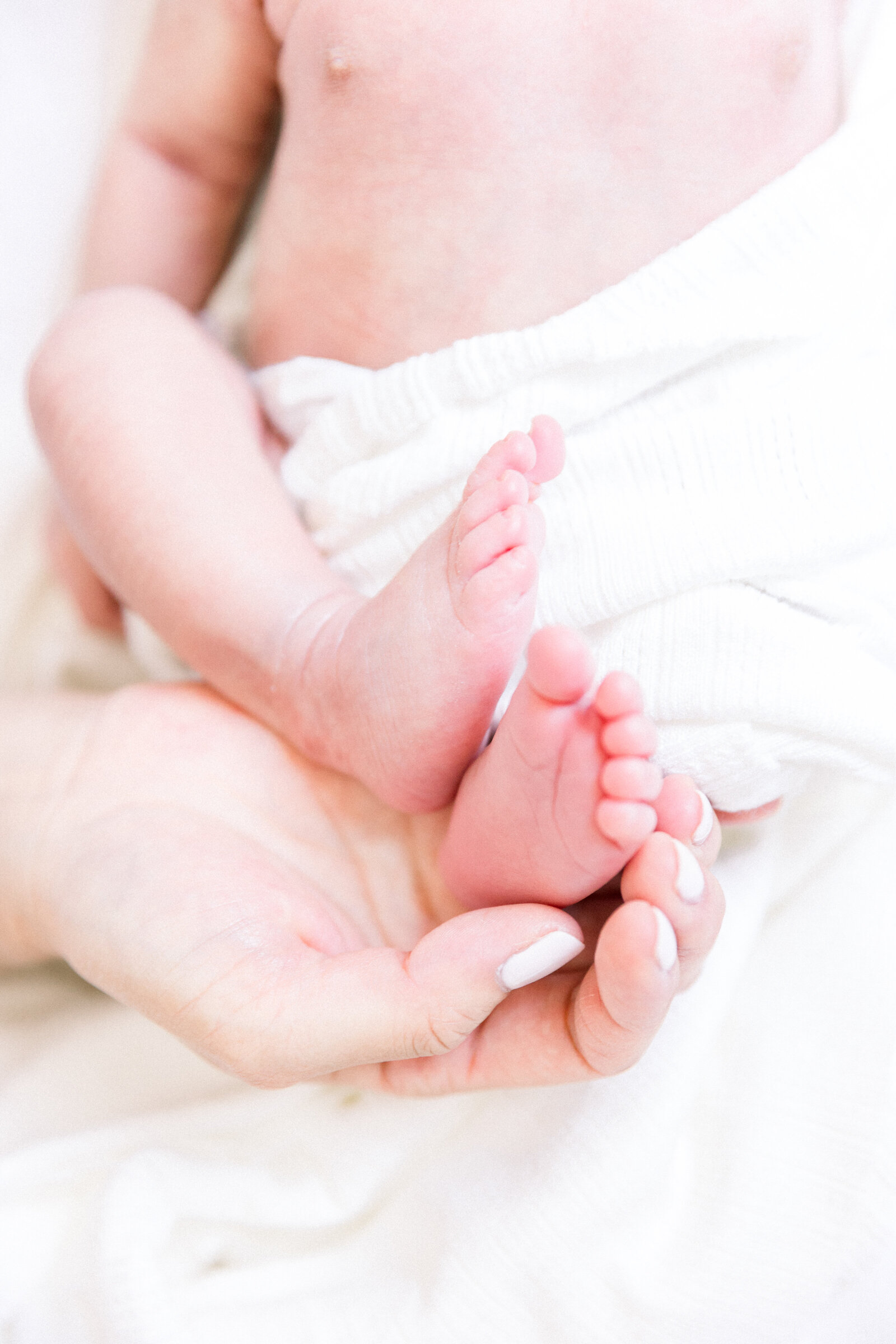 Image of baby feet and mother's hand taken by Sacramento Newborn Photographer Kelsey Krall