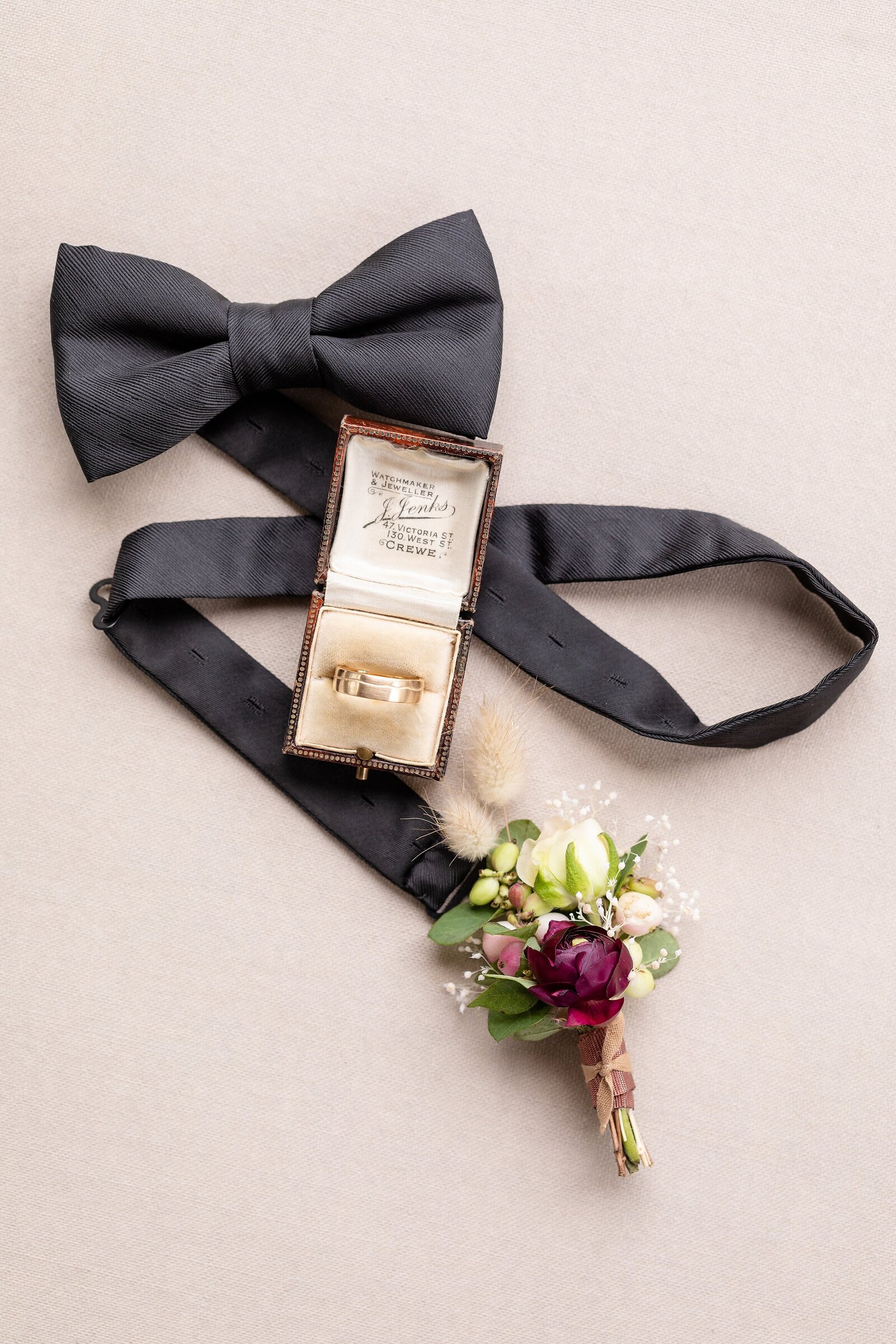 Groom-details-bowtie-rings-and-bouteniere-at-graydon-hall-manor