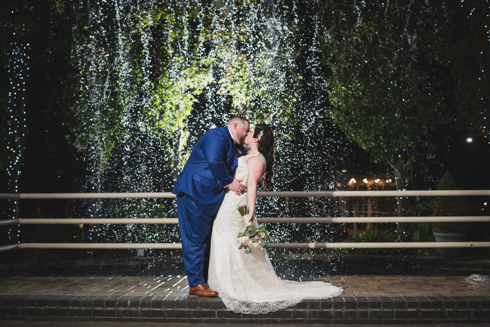 bride and groom kiss by fountain at Chateau Briand
