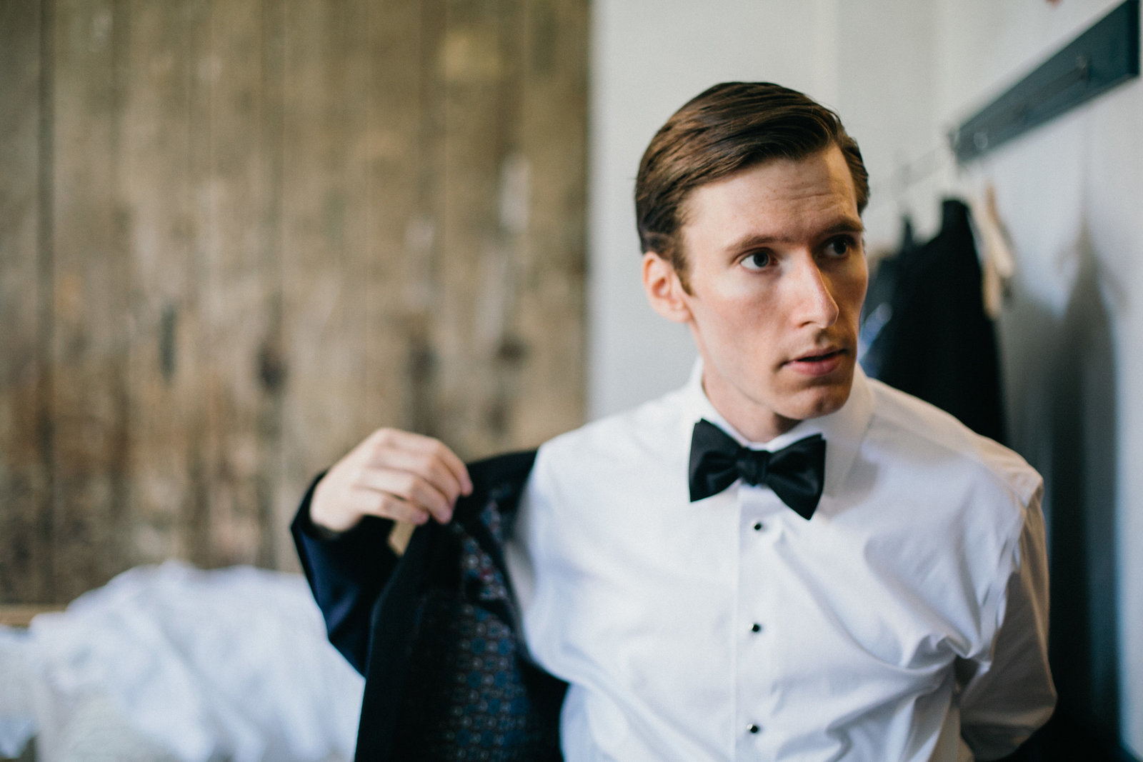 Handsome groom photographed getting ready at Lokal Hotel before the wedding ceremony.
