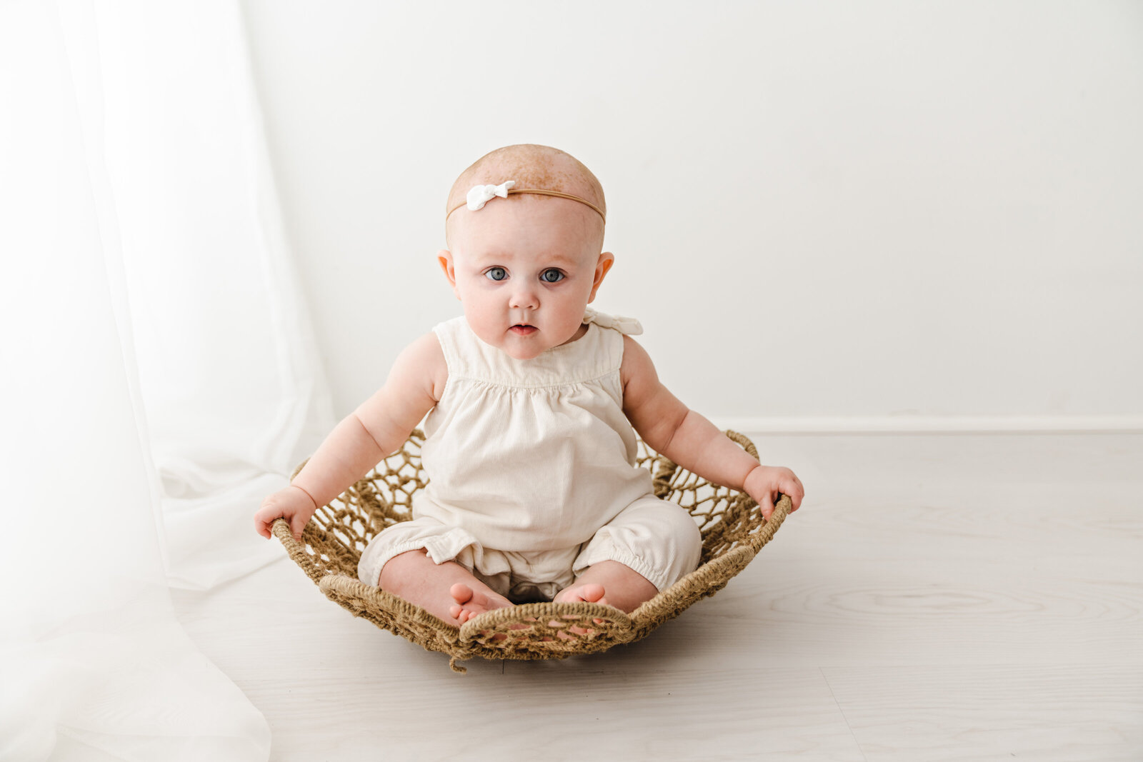 baby sitting in wicker basket