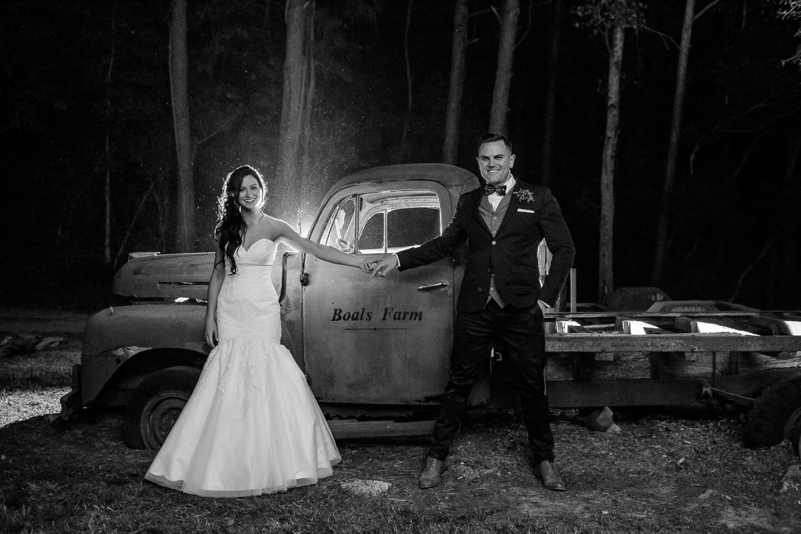 Bride and groom pose by red rustic truck at night, Boals Farm, Charleston, South Carolina