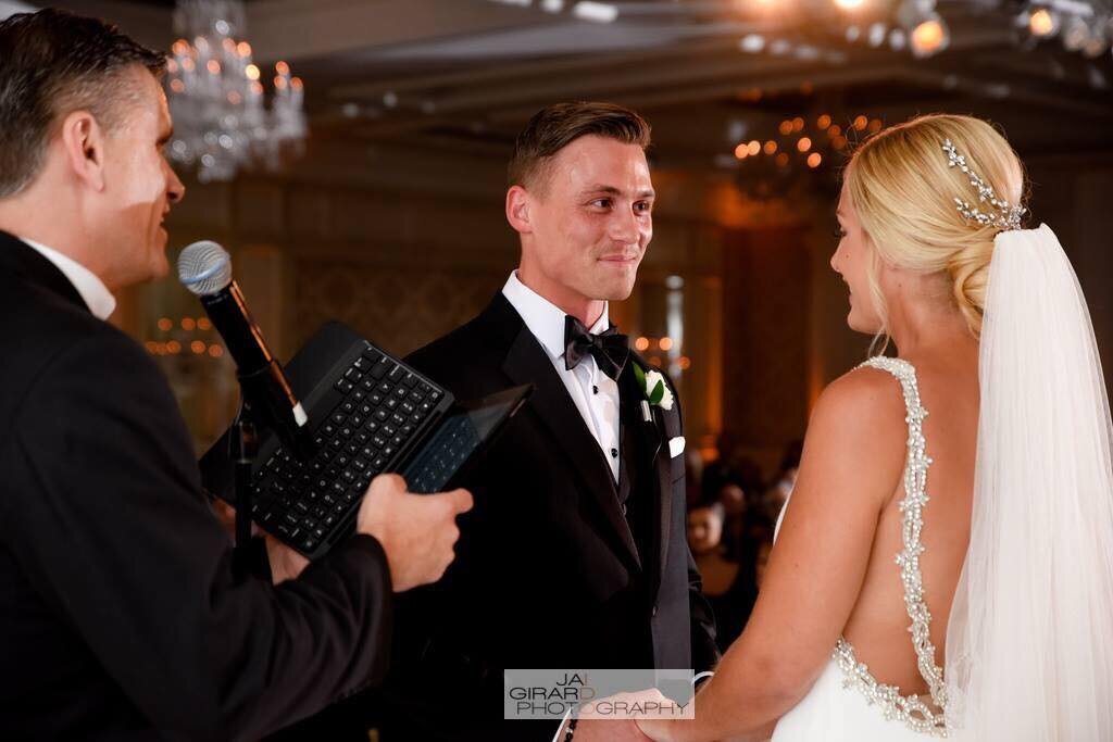 Groom smiles at his bride as he takes his vows