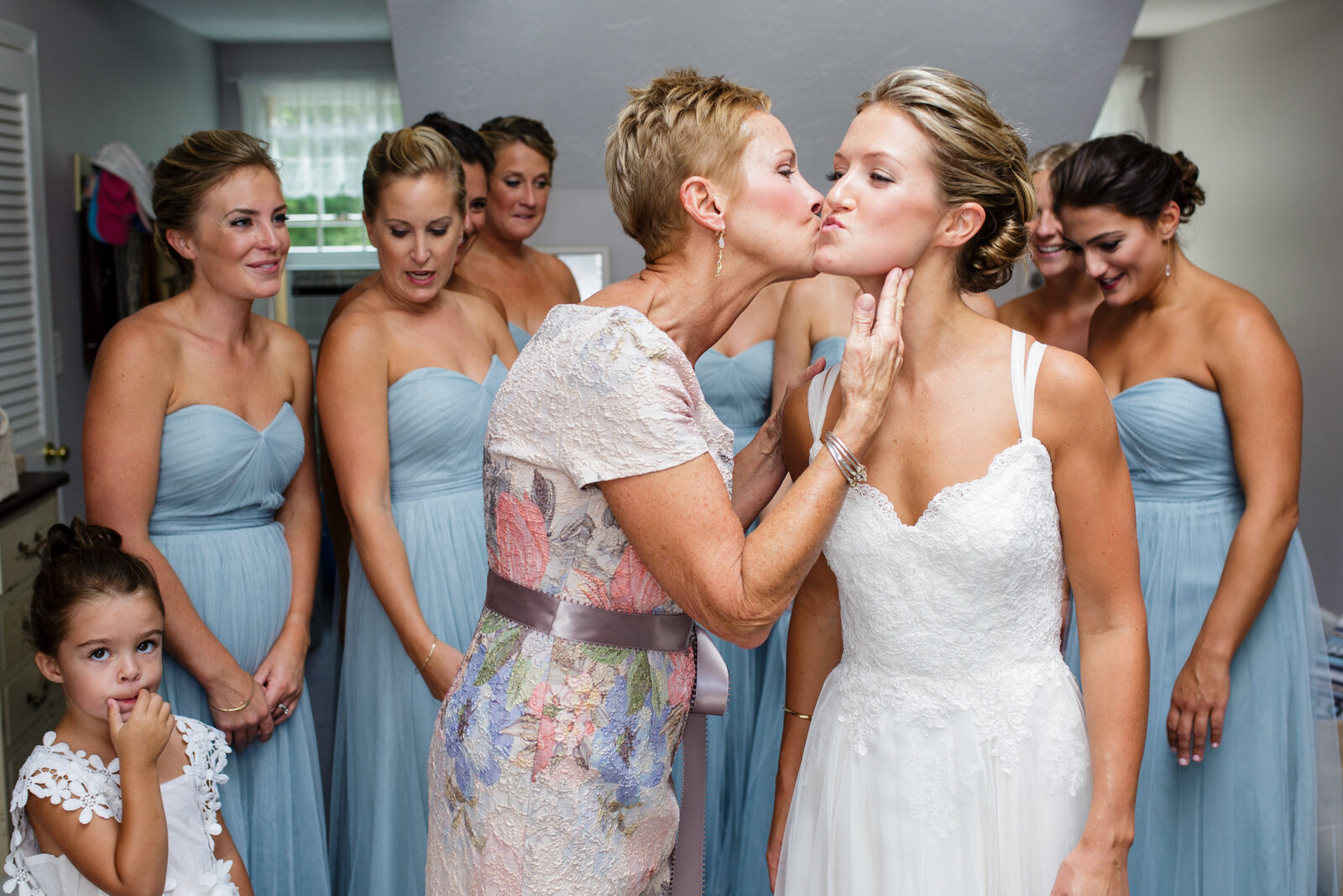 mother ob bride kisses daughter on the cheek