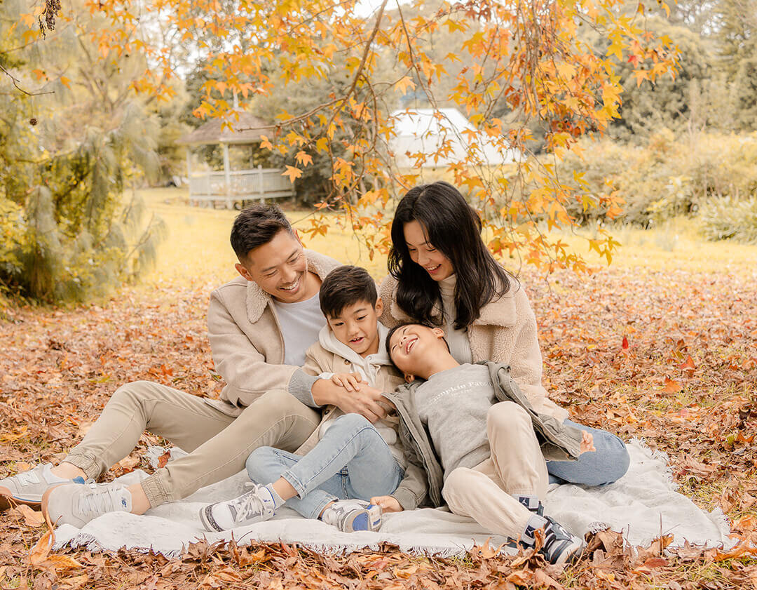 tickle fights during autumn extended family session in fall foliage in brisbane