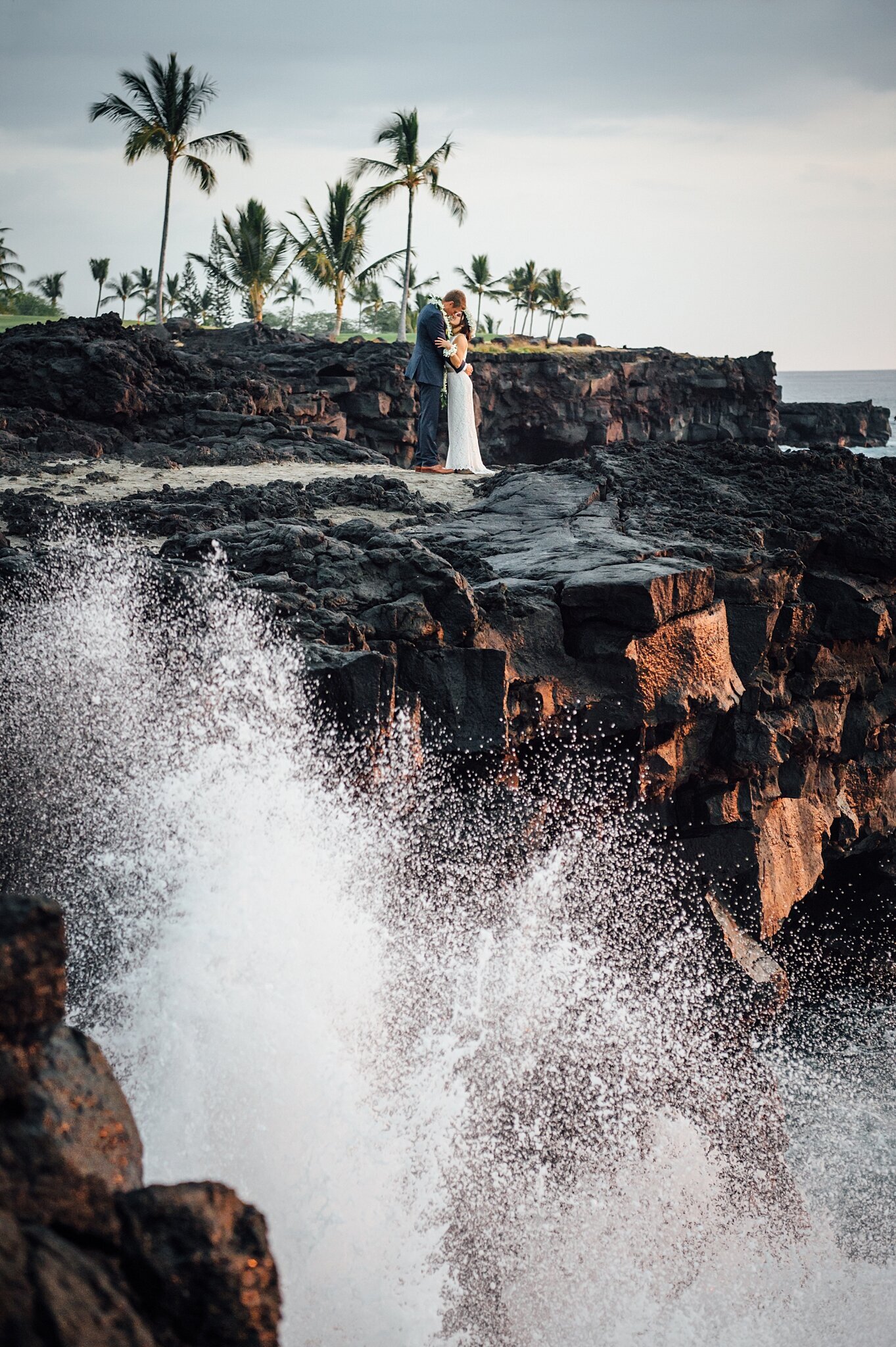 waves crashing on rock cliffs during wedding day in hawaii