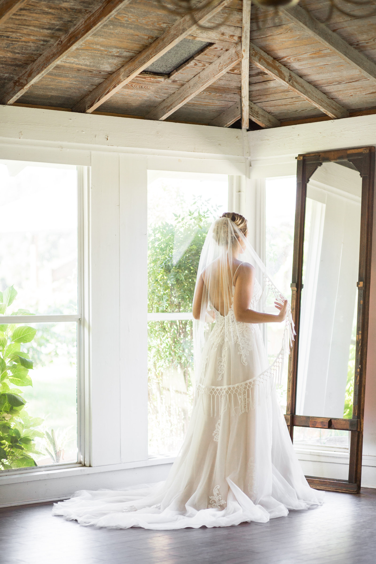 bride getting ready in front of mirror with windows all around at woodlawn plantation in guyton