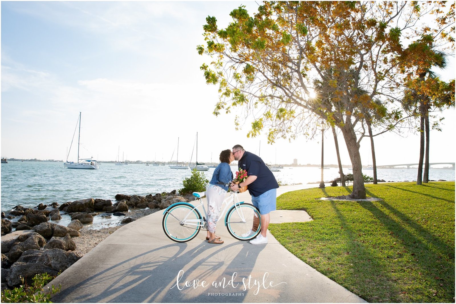 Engagement Photography at Bayfront Park, Sarasota kissing with a bike