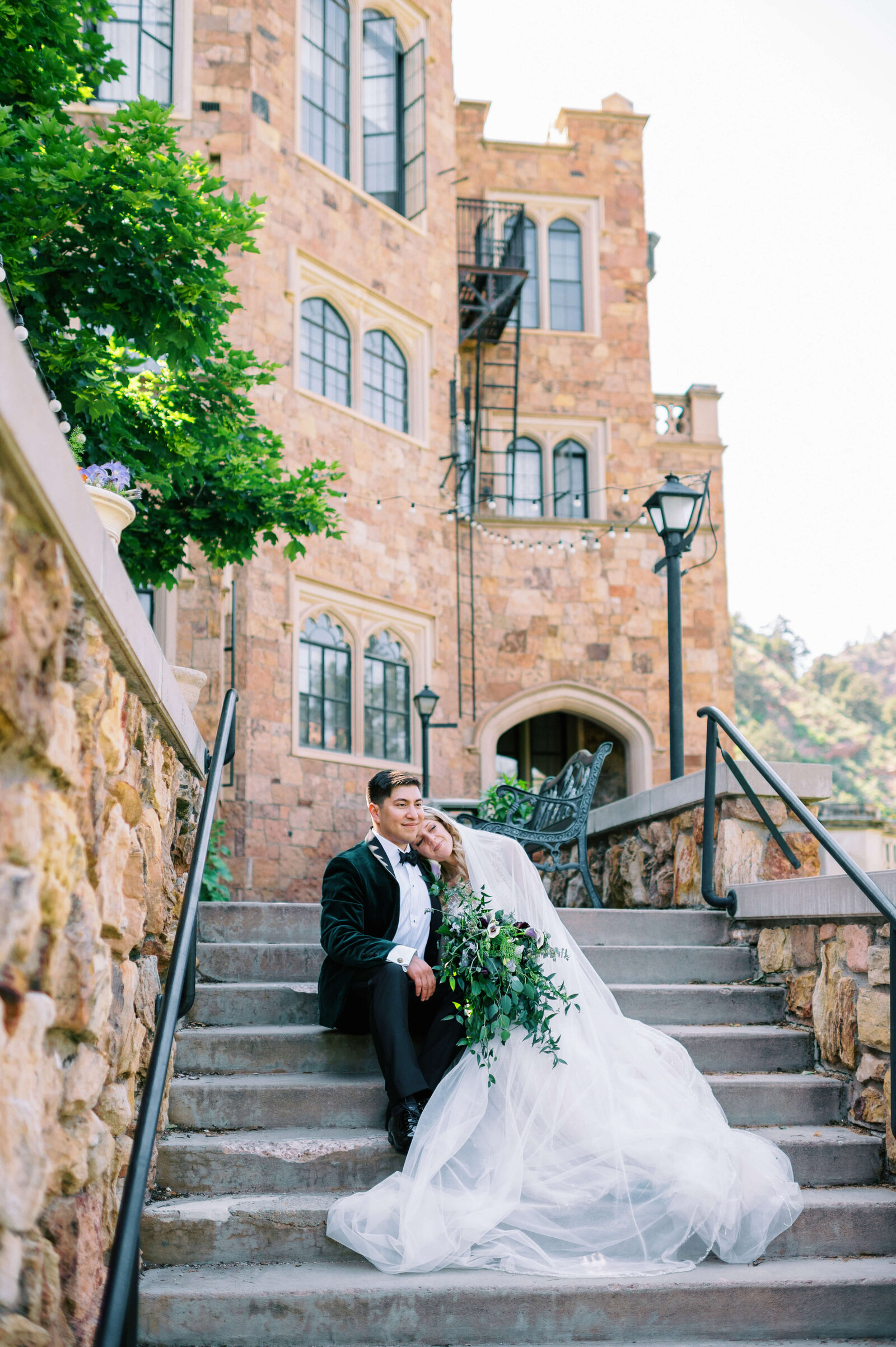 bride and groom cuddle together on the steps of an estate in a photo by Virginia wedding photographer