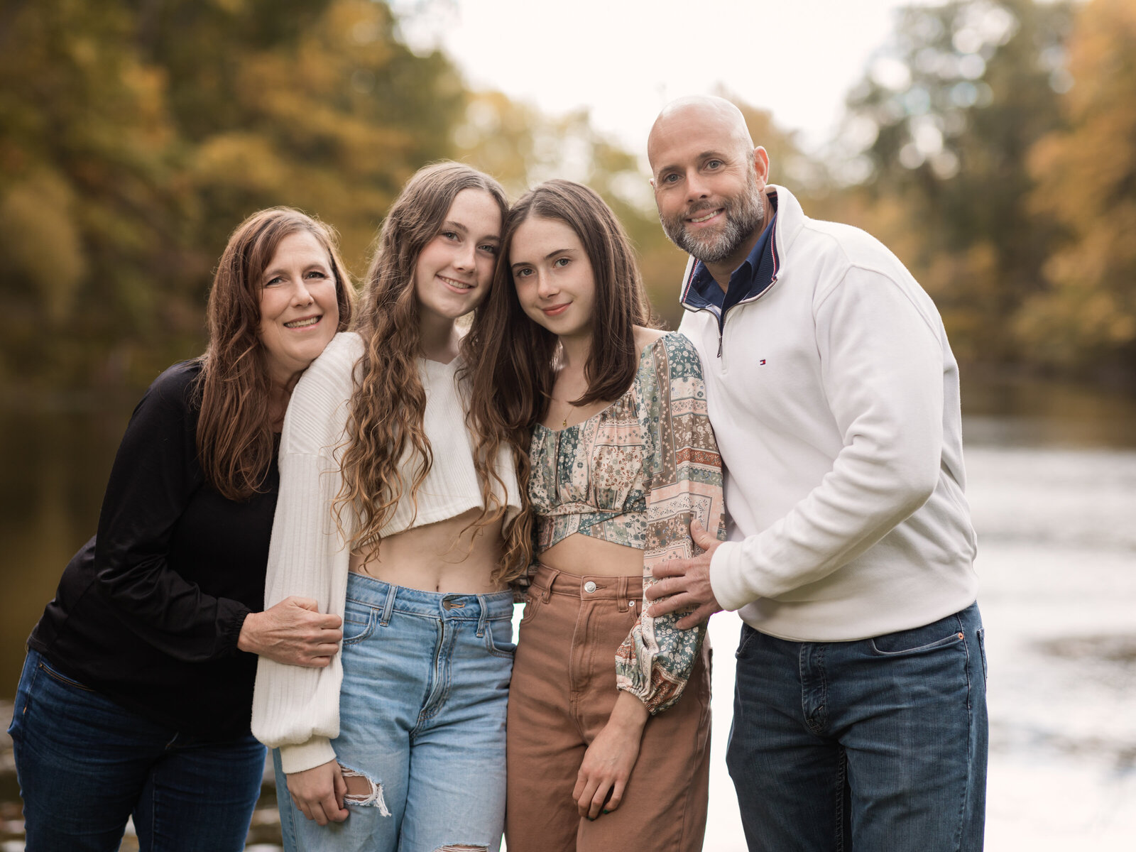 parents and two daughters posing for family photos at park