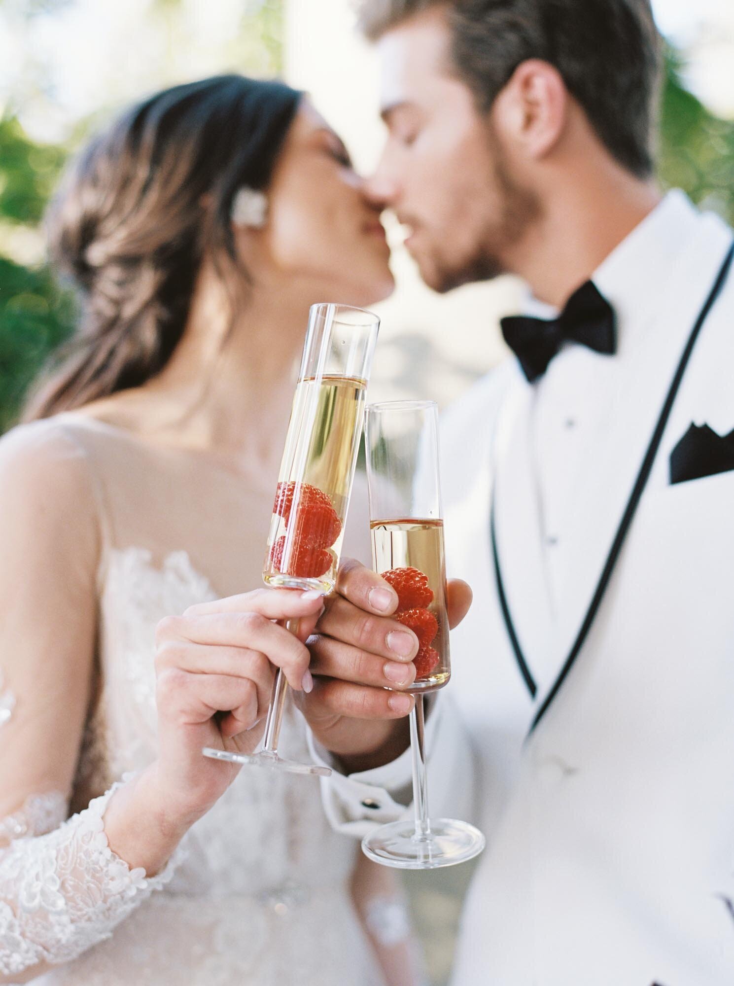Bride and groom having a toast while kissing