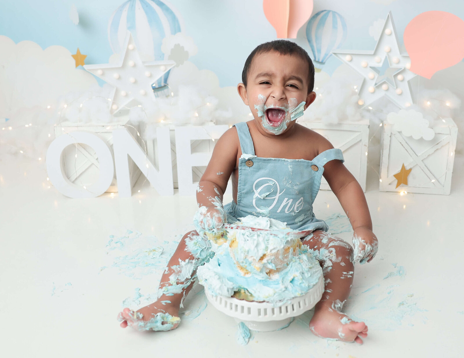 One year old boy playing in his cake at our studio in Rochester, Ny.