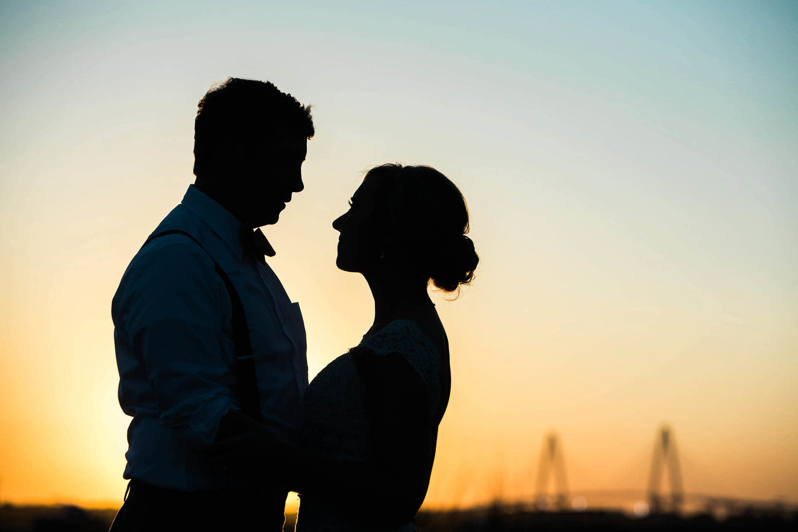 Bride and groom stand near Ravenel Bridge at sunset, Alhambra Hall, Mt Pleasant, South Carolina. Kate Timbers Photography.