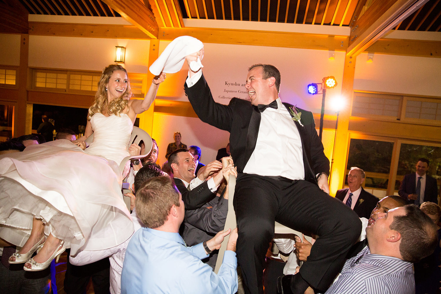 bride and groom lifted on chairs at the reception