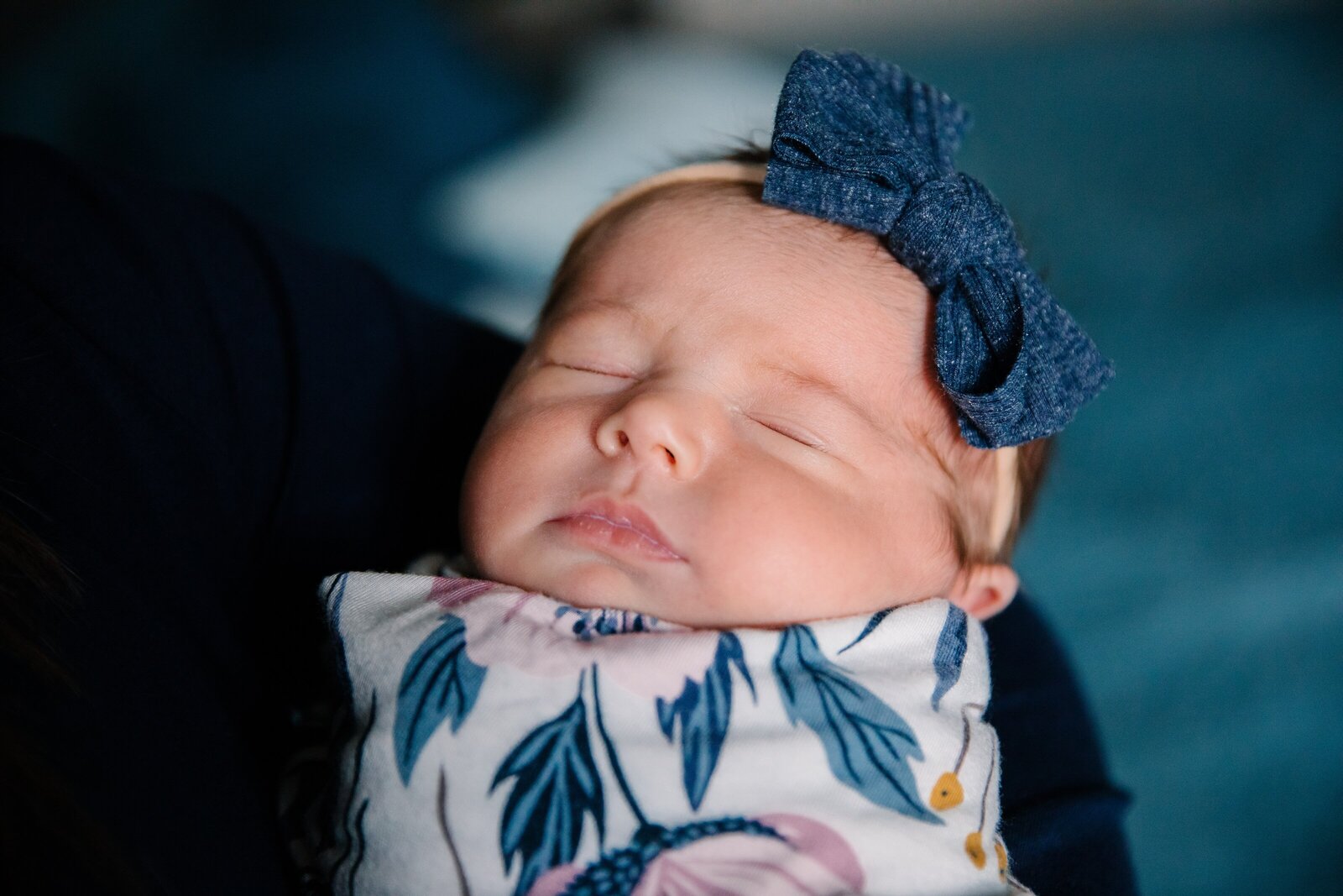 Sleeping newborn girl in floral swaddle during in-home  photo session