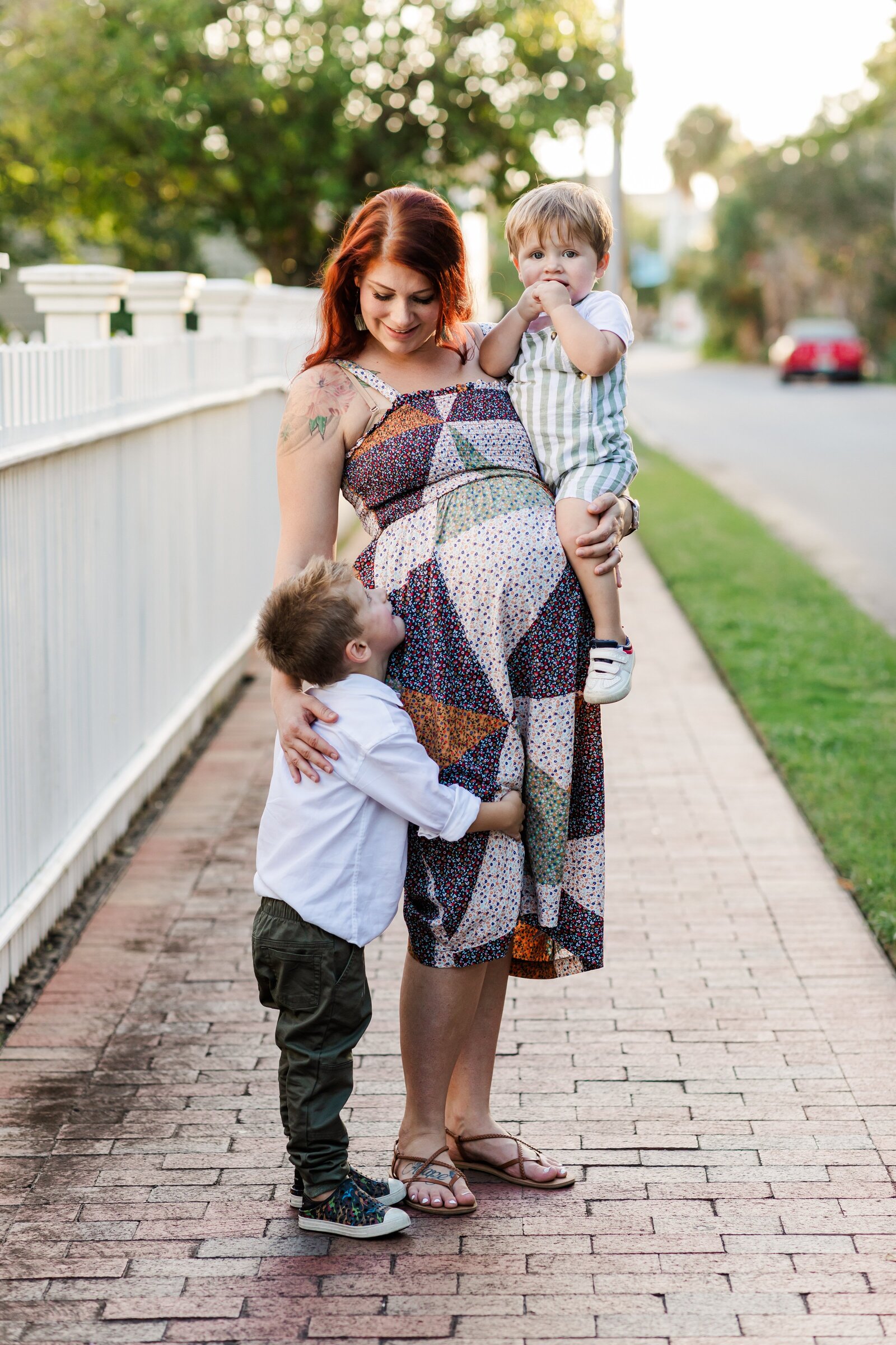 Downtown Pensacola Family Photography session with family of 4. Mom hugging two sons.