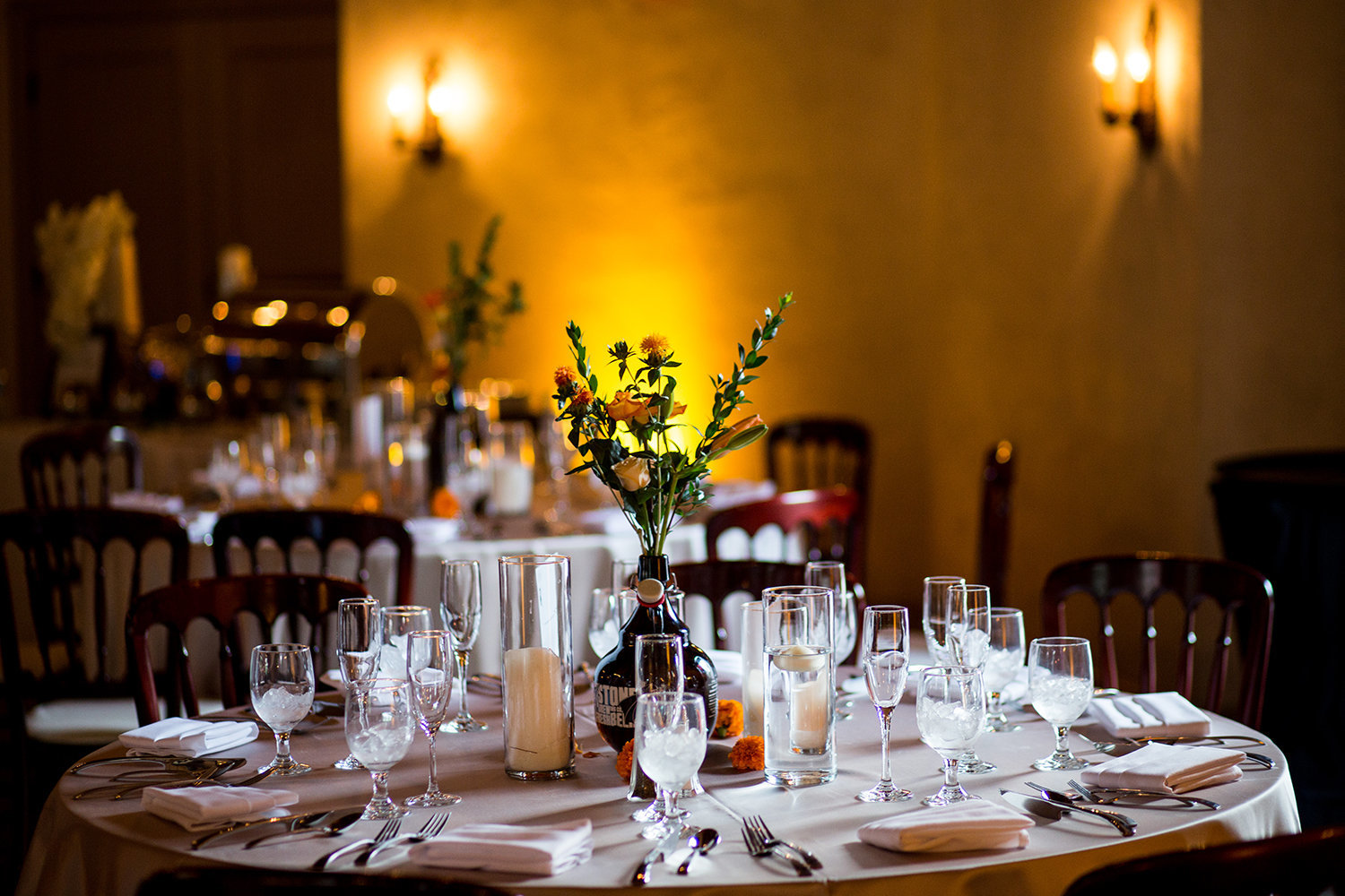 Warm amber uplighting set the perfect mood for this wedding table setting