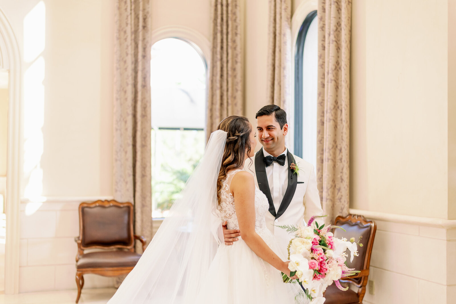 Groom looking at his bride with a big smile on his face in an elegant room