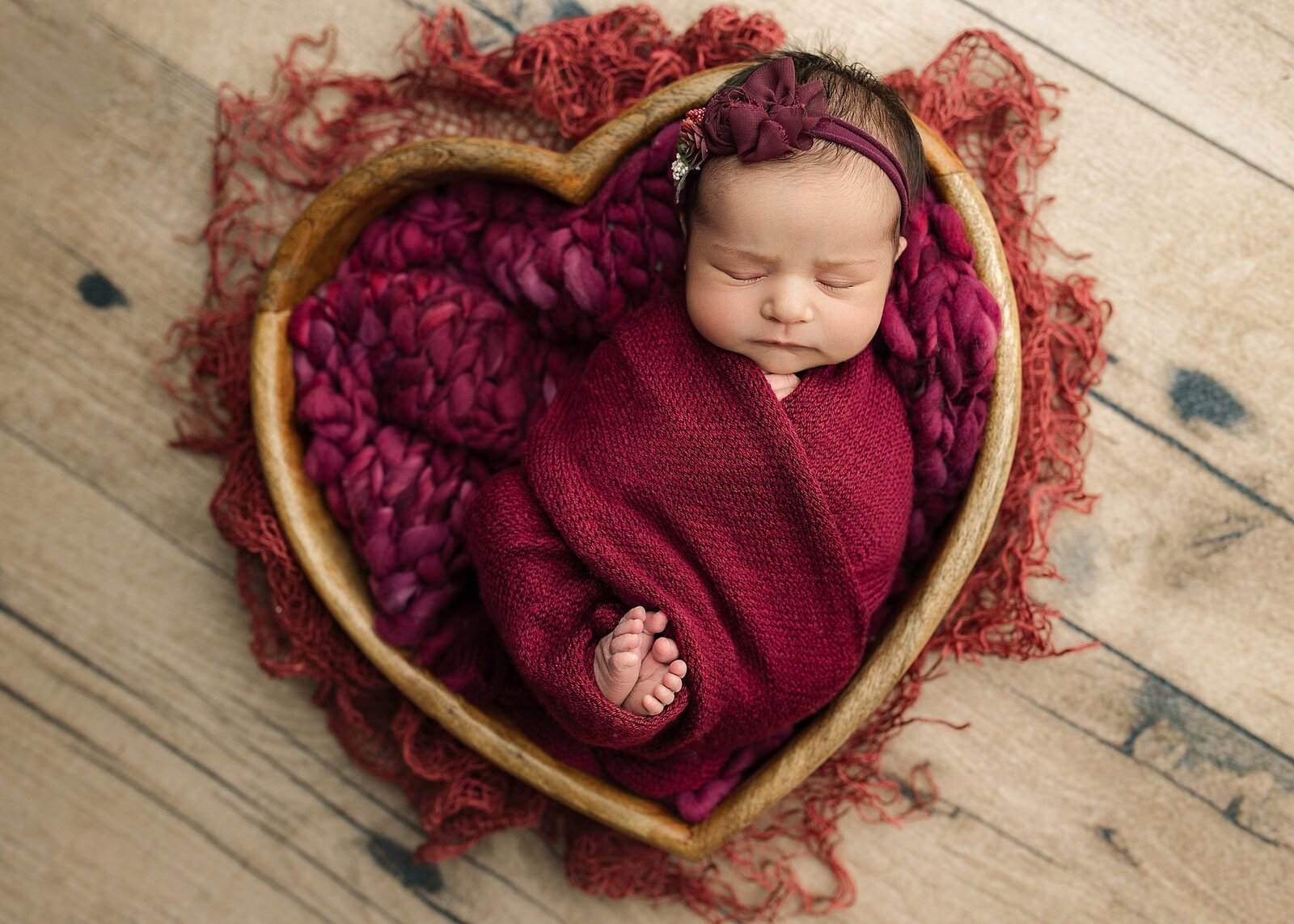 Baby girl wrapped in a heart bowl prop.