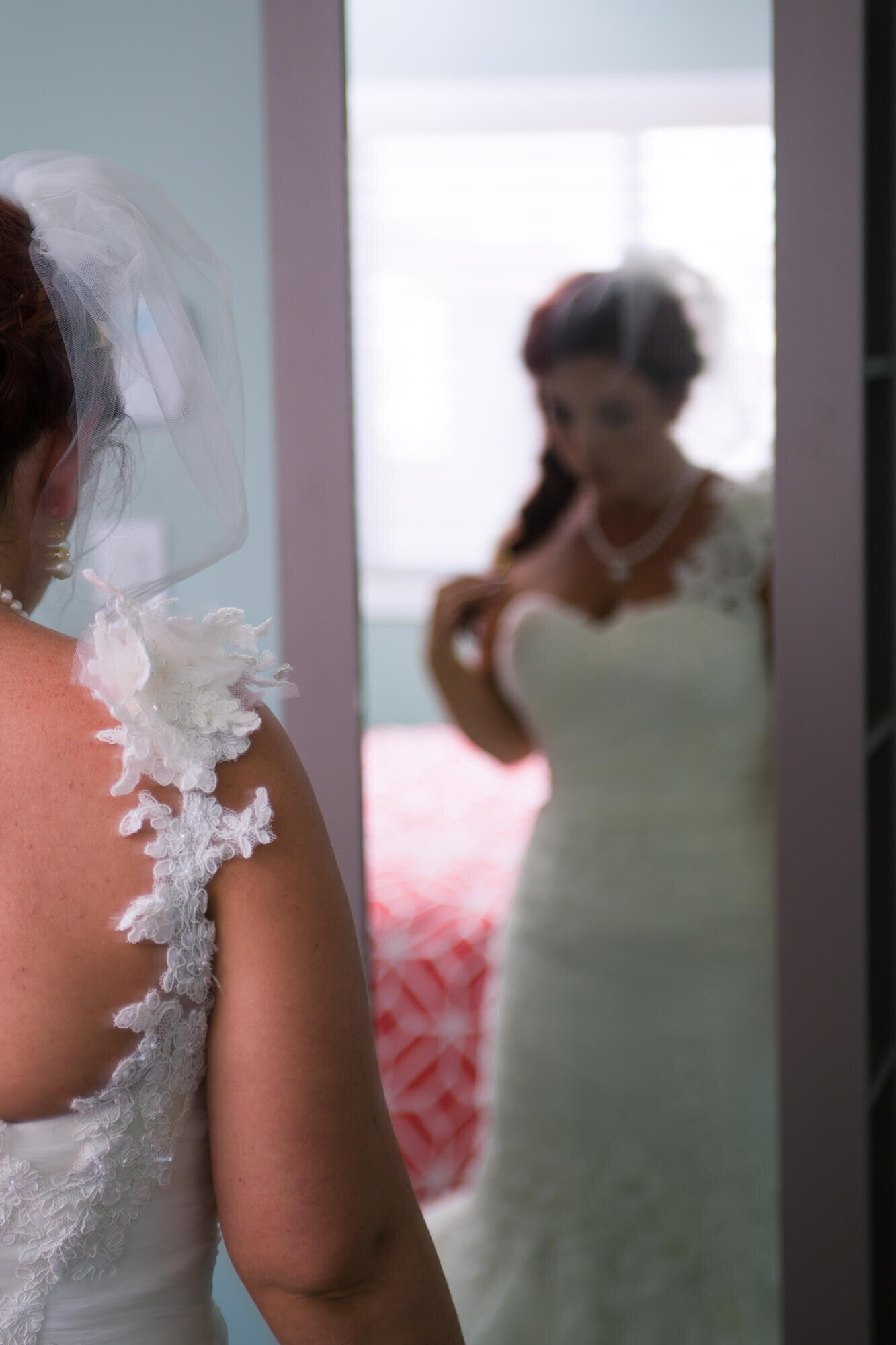 Bride looking in the mirror, showing elegance of dress