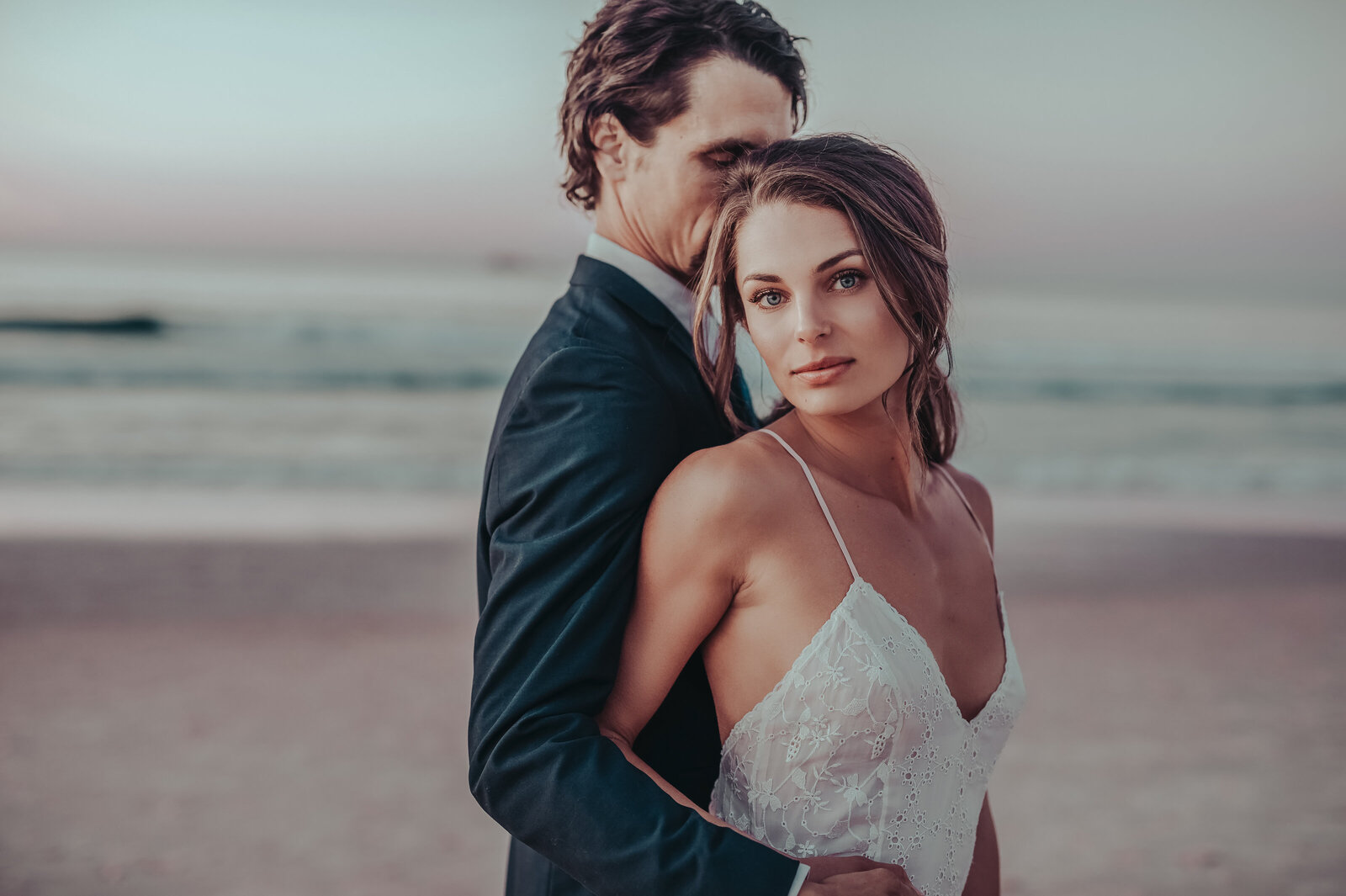 Newlyweds posing on the sand during beach wedding