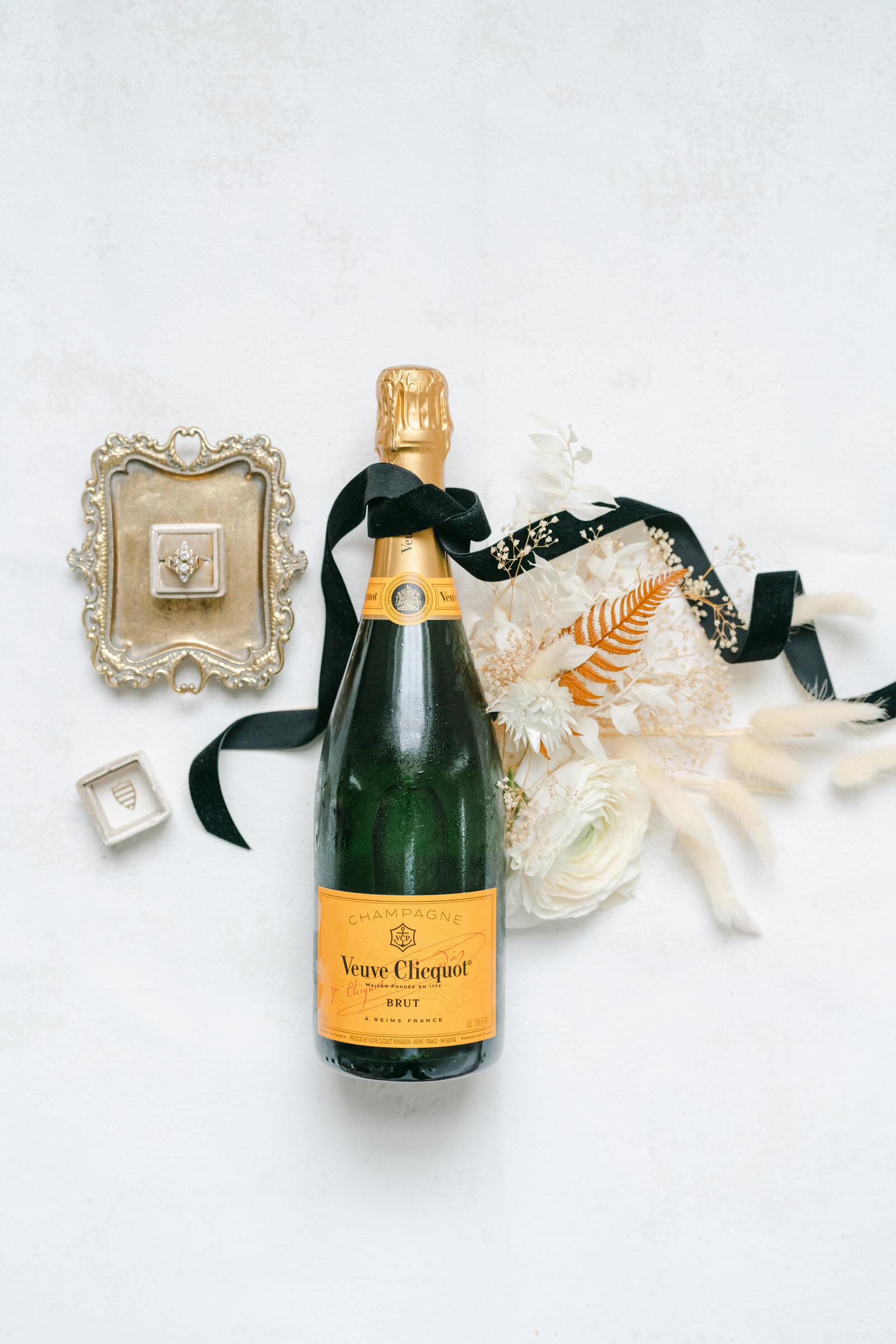 champagne bottle with flowers and wedding ring