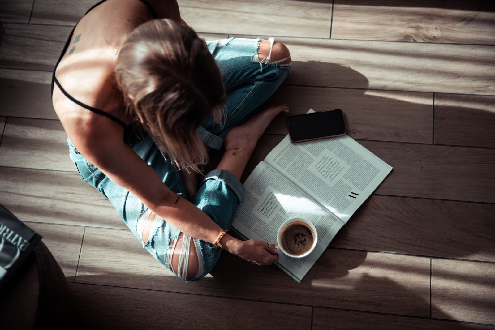 woman reading magazine with coffee cup