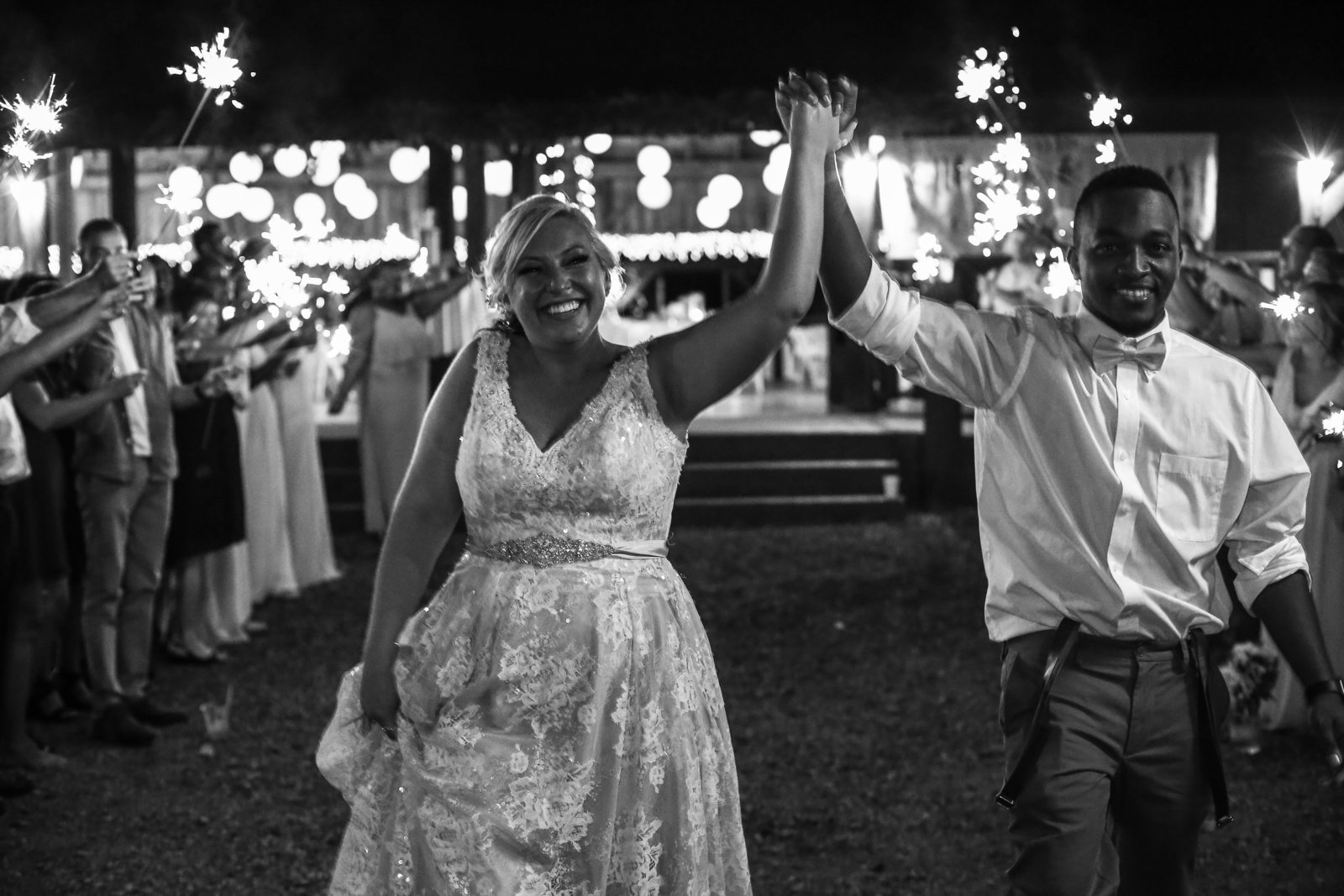 Guests hold sparklers as bride and groom leave Betsy's Barn wedding