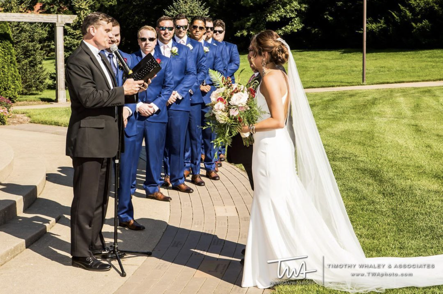 Bride and groom take their vows at outdoor wedding as groomsmen look on