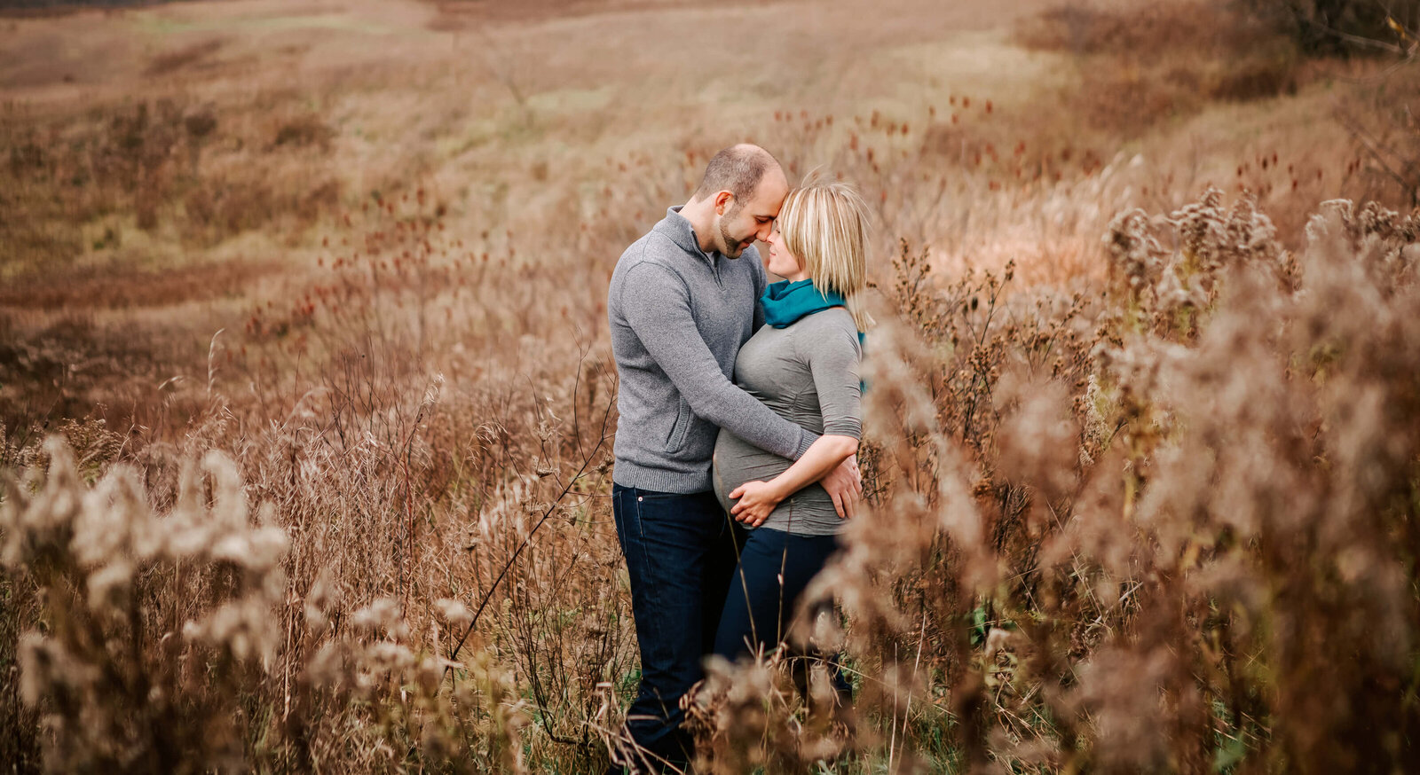 Husband and white rest their heads on each other during her maternity session.