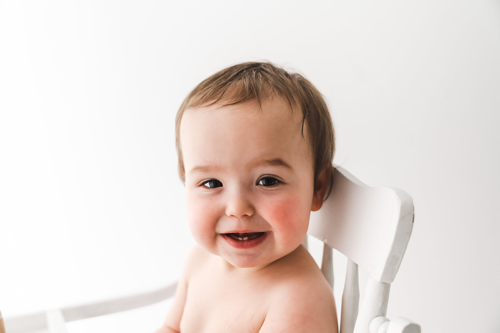 baby in white highchair