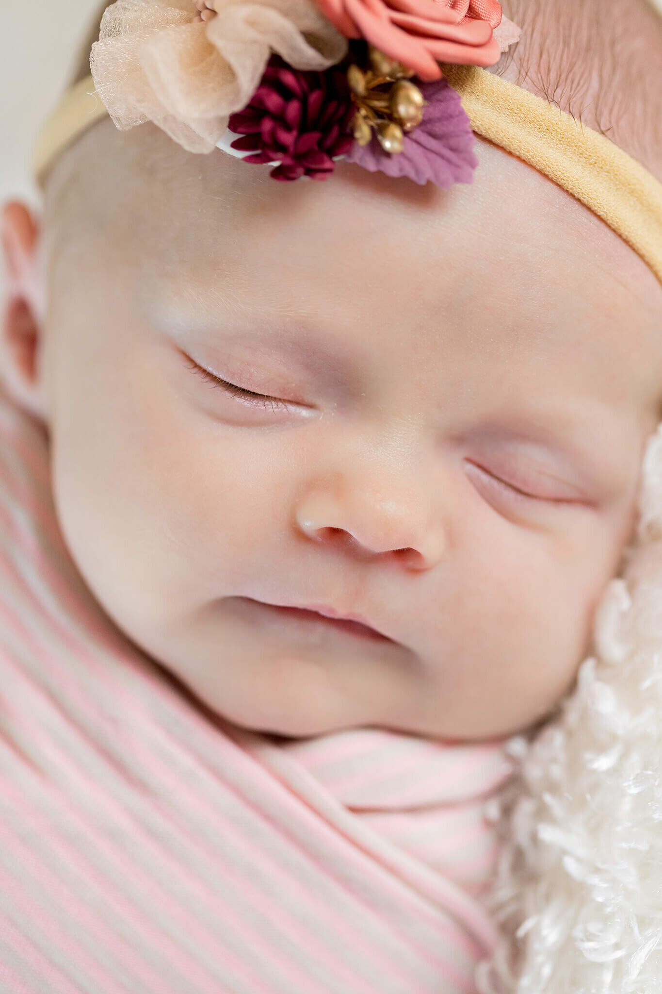 A close-up of a newborn girl's face with her eyes closed in Manassas.