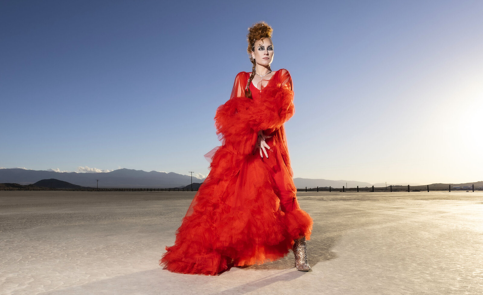 Women musician portrait Tarra Layne wearing red dress standing in desert