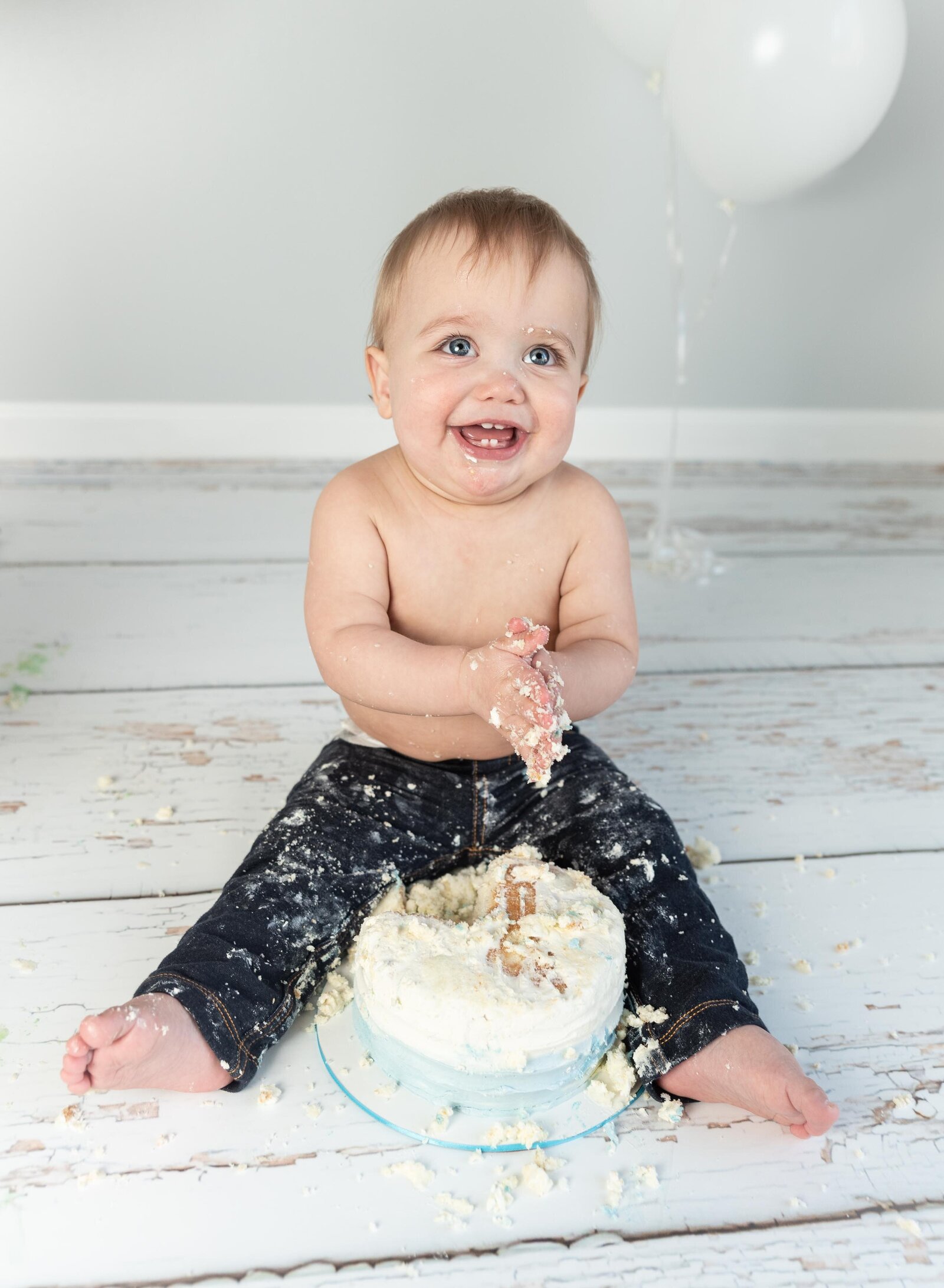 happy boy eating first birthday cake