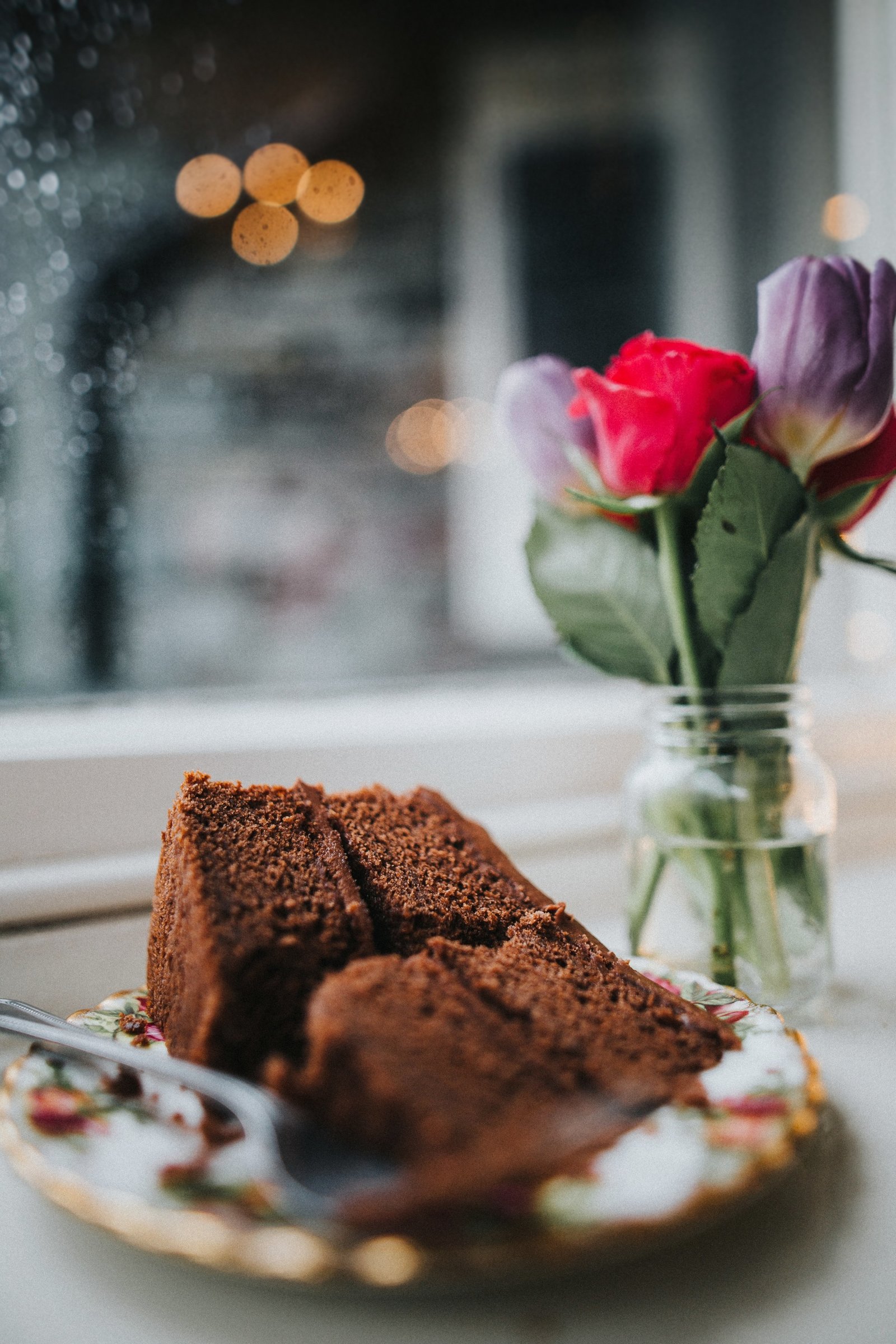 Slice of chocolate cake with bunch of flowers