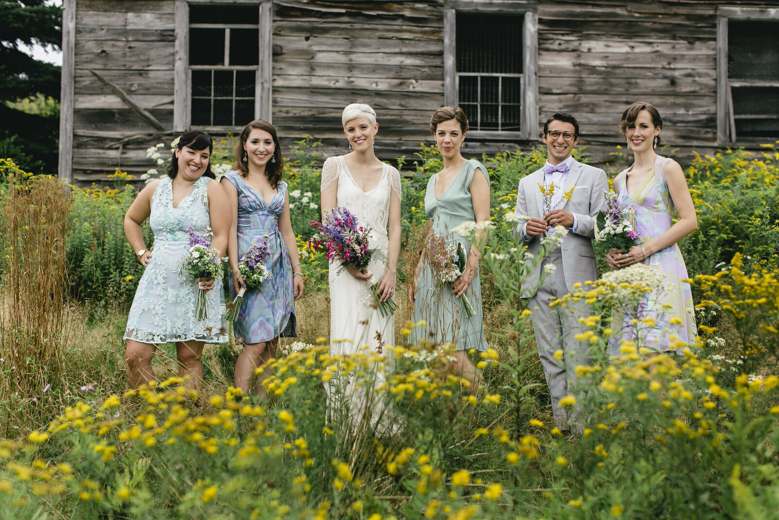 bridesmaids in yellow flower field barn