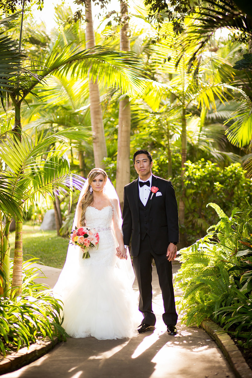 bride and groom serious with topical plants