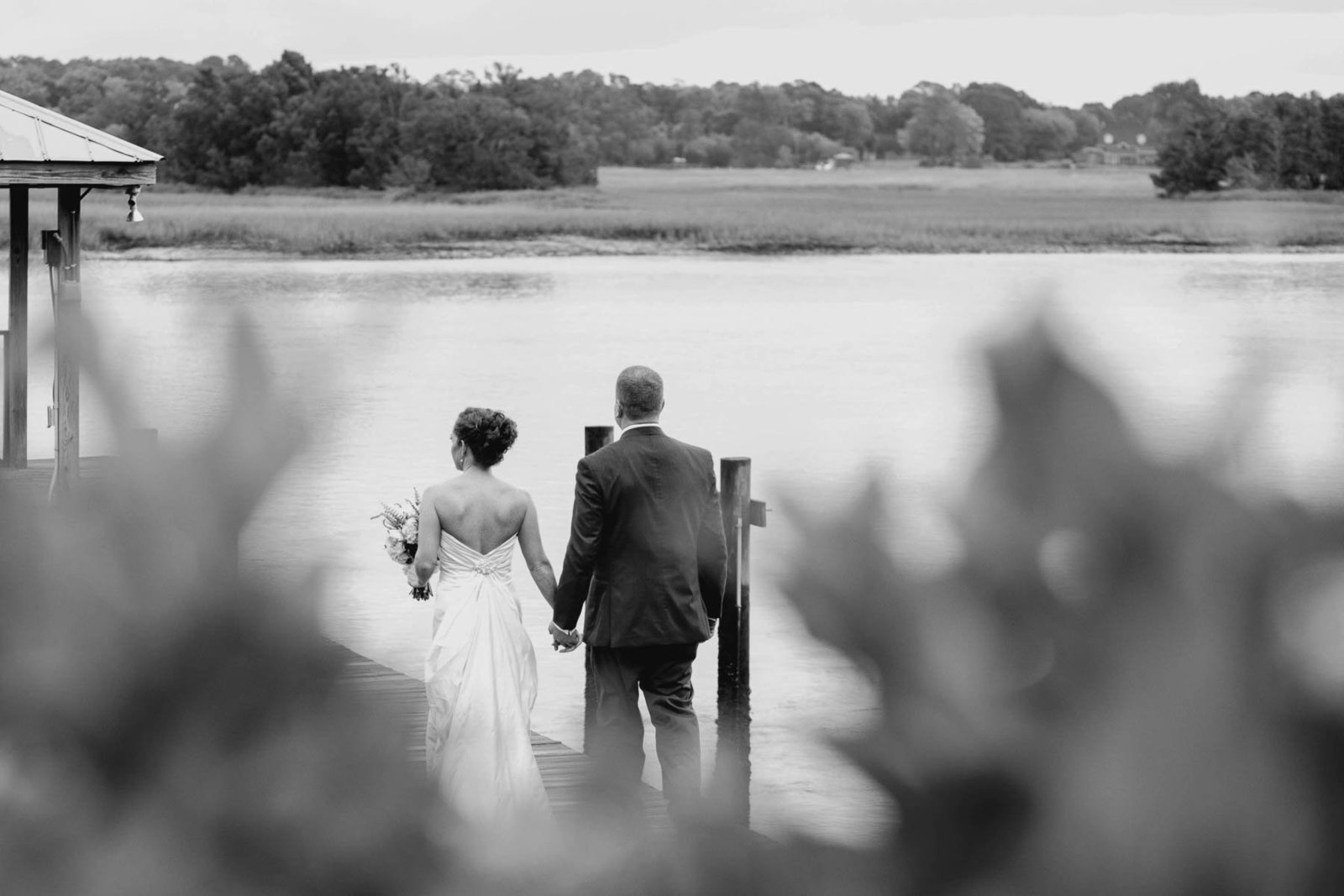 Bride and groom stand on dock, Old Wide Awake Plantation, Charleston, South Carolina