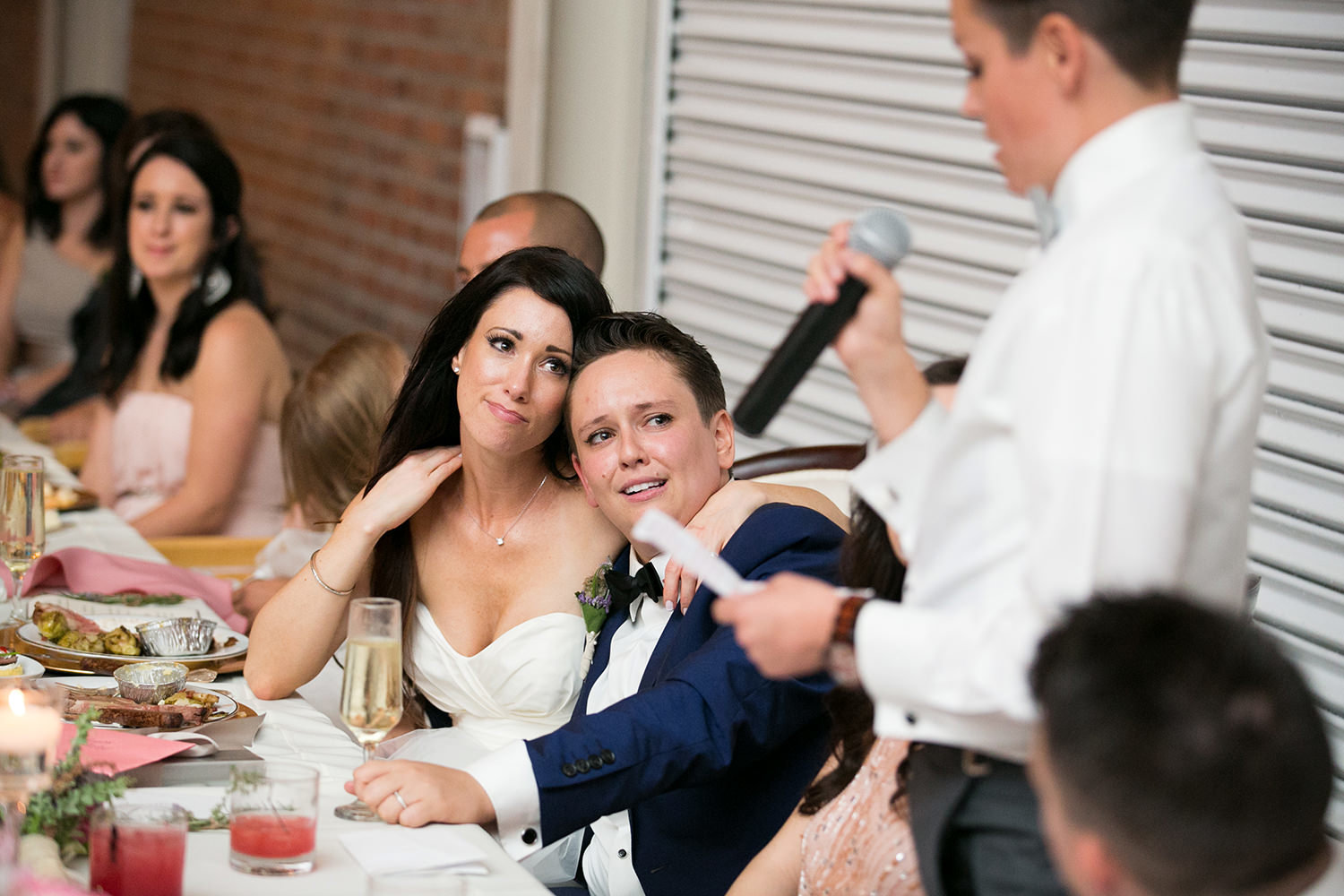 couple laughing at reception speeches brick