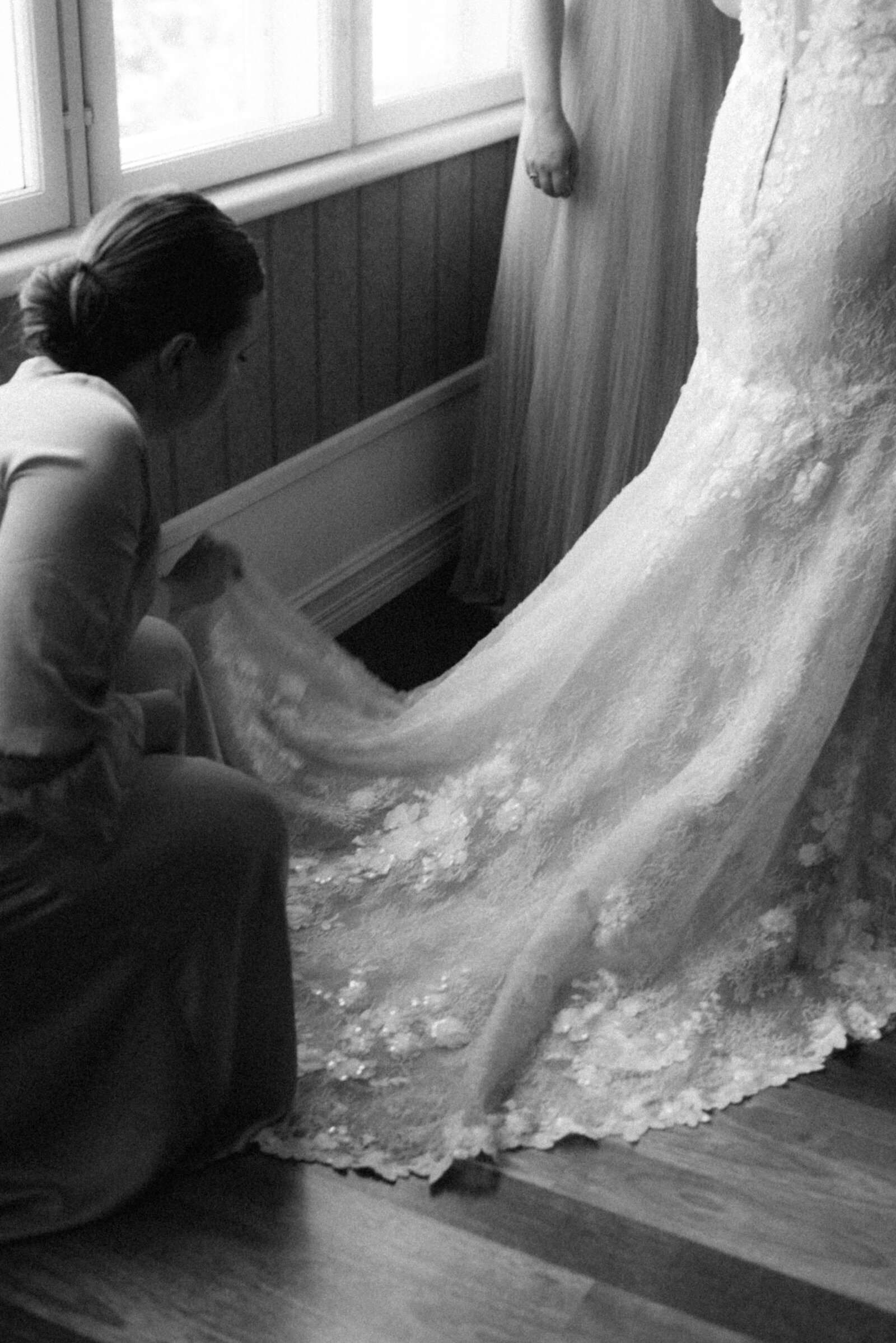 Bridesmaid setting the tail of the wedding dress in an image photographed by wedding photographer Hannika Gabrielsson.