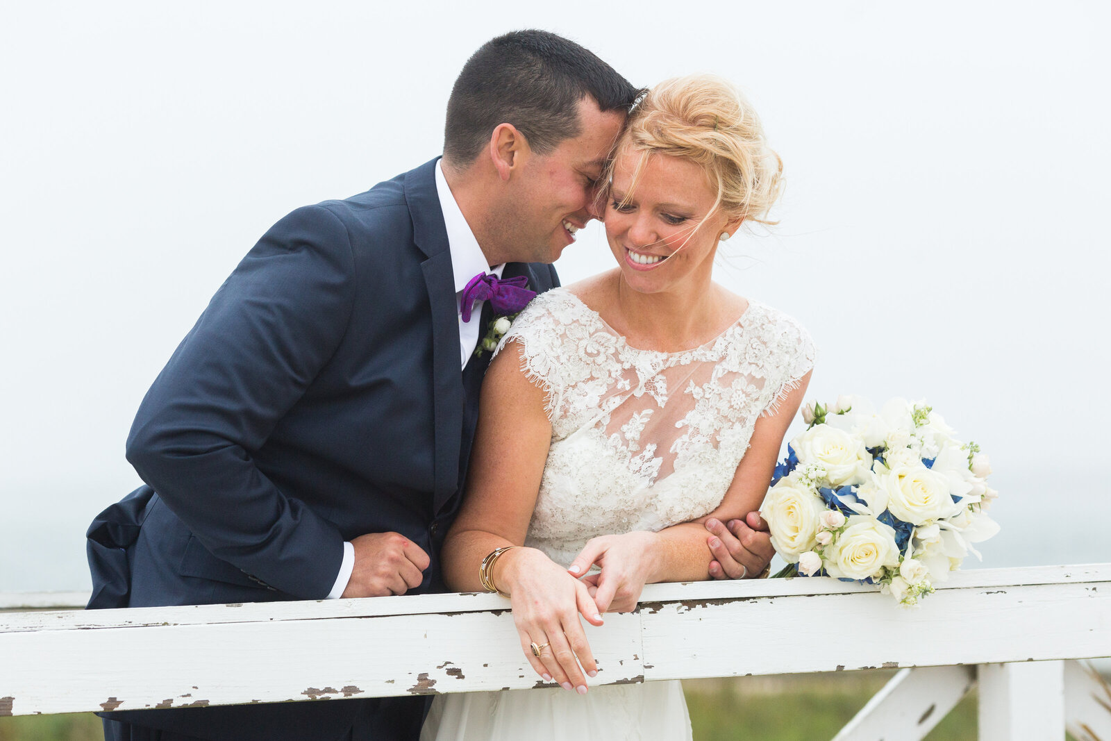 bride and groom with bouquet at lighthouse in nantucket