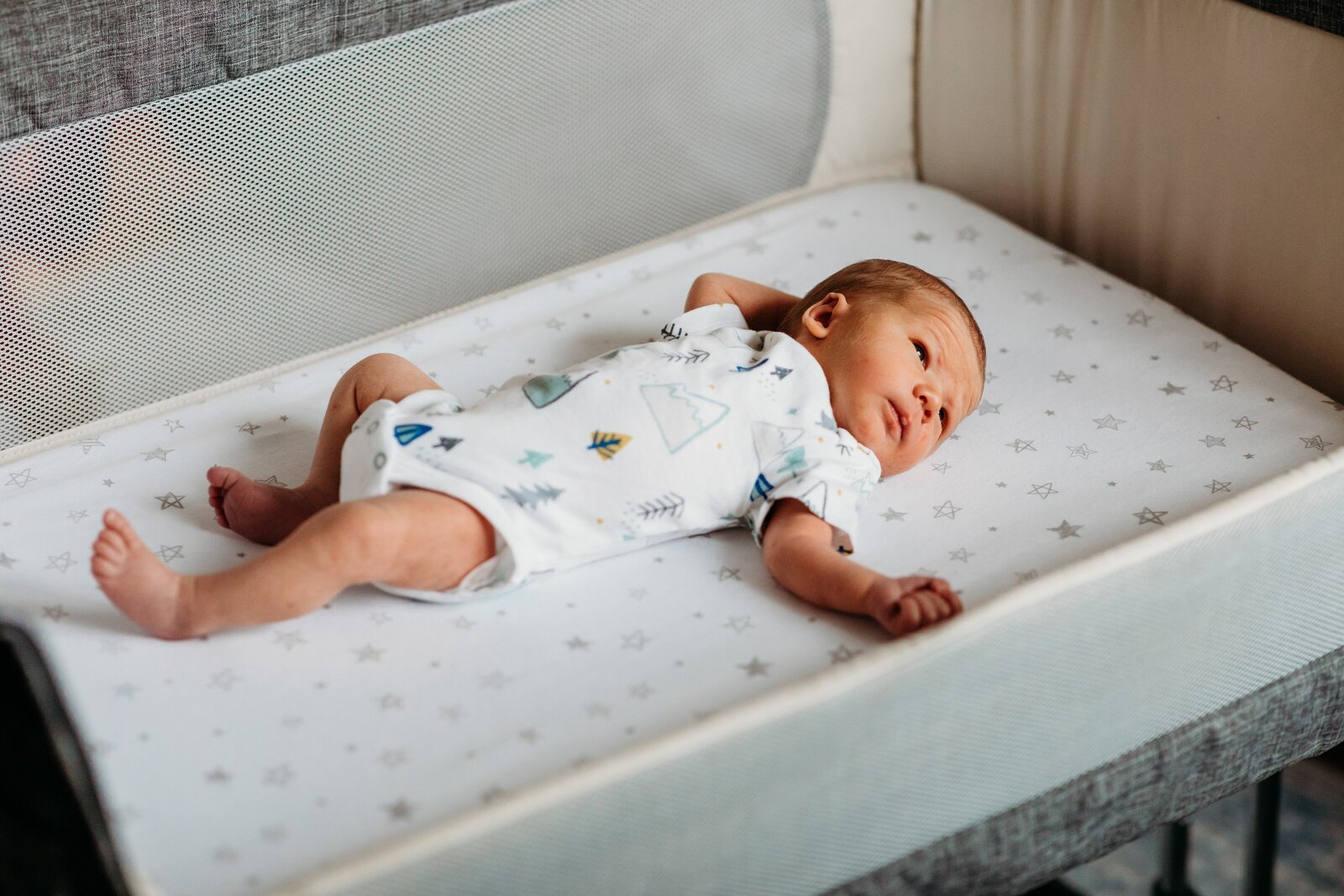 Newborn boy in bassinet during in-home newborn photo session.
